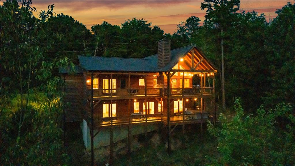 This is more than a cabin - it's a front-row seat to the Blue Ridge Mountains, with sweeping year-round views that stop you in your tracks the moment you arrive. Designed for both relaxation and unforgettable gatherings, this luxury log home delivers high-impact style with soaring cathedral ceilings, a dramatic wall of windows, and a brand-new deck made for mountain living. Watch the light shift across the ridges from your hot tub, share stories around the fire pit, or unwind with a book and the breeze - every corner is built to elevate your experience. The oversized primary suite offers generous space and a spa-style soaking tub perfect after a day of adventure. Downstairs, the game room and wet bar create a laid-back hangout zone for friends, family, or guests. A proven income-producing rental, this property includes modern touches like an EV charger and curated furnishings - fully turn-key and ready to go. And with tubing, hiking, fishing, and downtown Blue Ridge just minutes away, the location puts you right in the middle of everything that makes the Aska Adventure Area so sought-after. If you've been waiting for a mountain home that truly stands out - this is the one everyone will be talking about.