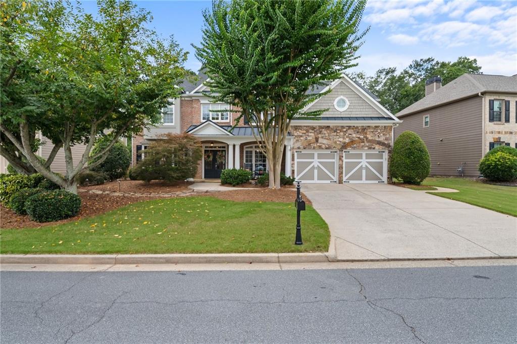 Welcome to this stunning 5-bedroom, 4-bathroom home located in the highly sought-after Lakefield Manor community, known for its exceptional amenities and vibrant lifestyle. This neighborhood offers a swimming pool, tennis and pickleball courts, playground, scenic walking trails, a lake stocked with fish, and a beautiful central park that hosts seasonal events throughout the year. This home stands out as one of the largest floor plans in the neighborhood and boasts a captivating front elevation featuring a combination of brick, stone, and shake shingles with HardiPlank siding wrapping around three sides. The inviting front porch and grand double-door entrance set the tone for the luxury that awaits inside. Upon entry, a two-story foyer welcomes you and opens up to a formal dining room on the right and a versatile living room or home office on the left. The main level includes a spacious guest bedroom and full bathroom, ideal for visiting guests or multi-generational living. The heart of the home is the chef’s kitchen, complete with a large island, granite countertops, a tile backsplash, abundant cabinetry, and a walk-in pantry, offering ample space for cooking, entertaining, and storage. A casual dining area off the kitchen is perfect for family meals and morning coffee, while the grand living room impresses with its coffered ceilings, floor-to-ceiling windows that flood the space with natural light, a cozy fireplace, and custom built-in bookshelves, all enhanced by elegant plantation shutters throughout the home. Upstairs, the oversized primary suite is a true retreat, featuring a serene sitting area, tray ceilings, and large windows that bring in abundant natural light. The beautifully updated primary bathroom includes dual vanities with generous counter space, a separate soaking tub, a frameless glass shower, and a spacious walk-in closet. This level also includes a conveniently located laundry room, a secondary bedroom with an ensuite bath, and two additional bedrooms connected by a Jack-and-Jill bathroom. For added flexibility, there is a large media room that could easily function as a sixth bedroom, home theater, or playroom. Outside, the level fenced backyard offers a perfect setting for outdoor gatherings, playtime, or simply relaxing in a private oasis. This home not only offers an exceptional floor plan and luxurious finishes but is also part of an active, friendly community that hosts a variety of events throughout the year, making it an ideal place to call home. Beyond your home, you’re just 10 minutes from the charming Marietta Square, offering fine dining, boutique shopping, seasonal events, and live concerts.For outdoor enthusiasts, Kennesaw Mountain trails are just a 5-minute drive away, perfect for hiking and reconnecting with nature. And if you're a sports lover, you're only 20 minutes from Battery Atlanta, where you can enjoy Braves games, concerts, events, and a variety of restaurants.
