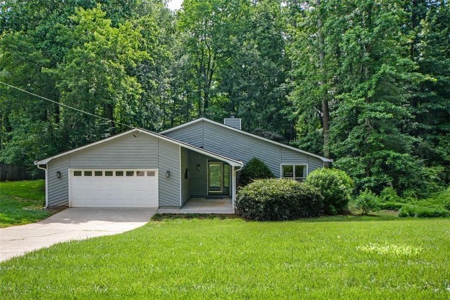 Fabulous opportunity! Three bed/two bath ranch situated on private serene backyard. Enjoy the nature from your amazing deck with modern railings. The deck is perfect for grilling, eating surrounded by the rustle of the wind and sounds of nature in your private wooded back space. Fabulous large flat stone path in back and raised stone bed. A small creek runs deep in woods making for amazing privacy! It's outside living space that is tough to find! Truly a lifestyle property with loads of potential. Once you enter through the covered front porch alcove you will immediately notice the fabulous sunken great room and soaring ceilings complete with 2 skylights and open design. The large rock great room fireplace invites you further into this one level easy living home.  Eat-in kitchen has been renovated to feature the beautiful sleek cabinetry, an abundance of counters, and pretty designer hardware. Bring out the inner chef in you with the gas range and stainless vent hood. Also featured: Stainless refrigerator, stainless dishwasher, and lovely slate tile flooring. Eat-in area looks to the private back area. Ample size dining room and wet bar area perfect for entertaining with family and friends.
Head back to the 3 bedrooms. They are large and a wonderful private space. owners bedroom suite has new carpet, a large walk-in closet, floor to ceiling windows and an updated private bathroom. Owners bathroom features: updated sleek designer  vanity and a large tile shower. The additional two bedrooms also feature the floor to ceiling windows, great closet space and are nice size rooms. Convenient laundry room near the bedrooms is a perfect size with cabinetry.
Don't miss the very large 2-car garage with attic pulldown and plenty of space in garage for lawn equipment, tool area and storage.  Don't miss the electric garage opener: Just pull directly down drive as the new homeowner directly into your easy-to-pull-in garage for a fabulous easy access to main portion of home and kitchen.
The gutters are covered so there is little maintenance for gutter cleaning. The property showcases beautiful hardwood trees in the backyard. Windows replaced. Roof replaced with skylights as newly added. Beautiful slate flooring throughout entire main living area.
