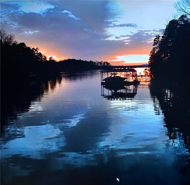5 ACRE LAKE LANIER ESTATE FAMILY COUMPOUND! LOCATION!! Buyer's Agents welcome. New 32x32 party deck double slip dock. The only available property like this on Lake Lanier. The value is the 5 Acre lake front land with NO HOA. This property has nearly 600 ft. of road frontage and can be subdivided into numerous lots. It has approximately 360 ft. on the Corp property line and approx 250 ft between docks on both sides with deep water. This private property is in a neighborhood of multimillion dollar homes. Sunset views from the dock and summer views of the lake from a 4-sided brick home with approximately 5500 sq. ft. with room to expand. This property is perfect for one who is looking for a lake property on the south end for a private compound to enjoy as is or develop more homes for your family, rentals or to sell. Build barns, have horses, additional garages/shops, pools, tennis courts, pickle ball courts, green house, gardens. Simply endless possibilities. Even tiny homes are welcome in Hall County. Two separate portions of the property can be divided that would be lakefront and would meet the Corp requirements of applying for 2 more dock permits by sign up on a waiting list. The future value of this property may be enormous because lakefront land is running out; especially on the south end of the lake and 5 minutes from the interstate and major shopping areas. Large area to park your RV, boats, trailers, trucks or equipment. NO HOA! Approx 3500 sq. ft. on the main level. Oversized Master on main with 3 closets and wood burning fireplace. All seasons view of the lake from every window lake side. Large bedrooms with their own private full baths and walk in closets. All interior doors are solid wood, with crown molding. Cozy family room with wood burning stone fireplace. Large separate dining room overlooking the lake that can seat 12. Large sunroom overlooking lake with 15 glass pane French doors to family room and double full glass exterior doors opening up to the main level deck which connects the master suite to sunroom. Approx 450 sq. ft. bonus room with large walk-in closet and window. The terrace level has large decks and a patio. Appox. 250 sq. ft. covered front porch, large enough for sofa and chairs viewing a manicured private courtyard with no steps or stairs. Real solid 3/4 red oak hardwood floors throughout, (no Carpet) with tile in all 5 bathrooms. The driveway is approx 600 ft long almos the length of two football fields) which the home cannot to be seen from the road. In addition, the road is a dead-end road, little traffic and a cul-de-sac. A quiet cove with no skiing, wakeboard boats or jet ski traffic at more than idle speed. This large 5 Acre track is nothing short of a private peaceful paradise. Parties/events? Park as many as 50 or more cars without using the street. Investors, Builders , Developers or Corporate Housing: Huge potential future value is there for this gem of a large 5 Acre property. Need to park some money? With rental/investment possibilities a 1031 may be perfect for you. With No HOA, it's a major plus for those seeking flexibility, build a large mansion, barn dominium or build the minimum requirements per Hall County GA. With the increasing demand for lakefront land this property is well-positioned for future appreciation, particularly given the rare combination of privacy, expansive space, and potential for further development. This is the only opportunity to acquire such a property with the above-mentioned aspects and elements. Although after viewing this property, one may want to keep it all in tack as is and enjoy this beautiful wooded property, home, dock, lake and all it has to offer. for your family compound. Plus, it's a short boat ride (ten minutes) to restaurants, parks and marinas on the lake. Shown by appointment only. Buyer's Agents welcome.