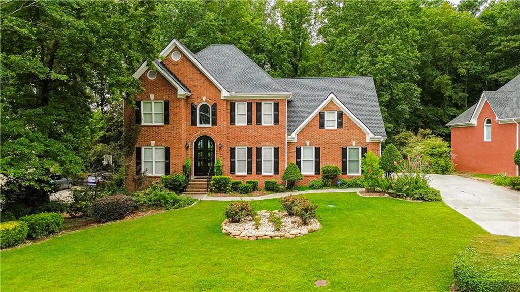 Behind its timeless brick façade and double arched doors, this Lakes of Old Peachtree home delivers style, space, and sophistication in the sought-after Mountain View HS district. A sunlit foyer opens to a fireside family room with soaring ceilings and picture windows, flowing into a sleek white kitchen with stainless appliances, stone counters, gas cooktop, and double ovens.
Upstairs, the primary suite impresses with a tray ceiling, sitting area, spa bath, and boutique-style closet, joined by four additional bedrooms. The finished terrace level is built for entertaining with a full bar, media/game lounge, theater room, fitness space, and walk-out access to the backyard.
Outdoor living shines with an oversized deck, covered patio, and deep, level lawn framed by mature trees and blooming roses. With a like-new roof (2022) and access to swim/tennis amenities, this move-in ready home offers a perfect blend of elegance, comfort, and convenience—minutes to Mall of Georgia, I-85, and Hwy 124.