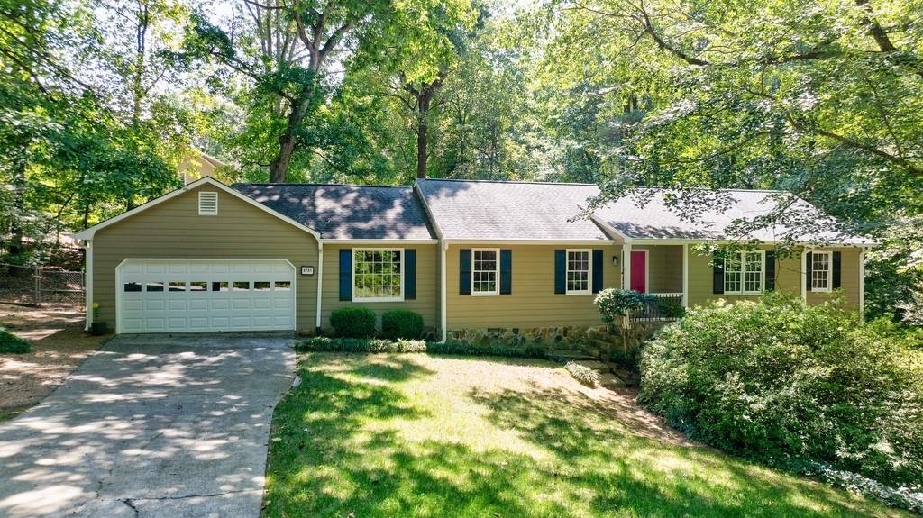 You won't want to miss this charming 4 bedroom ranch home located in the highly sought after Pope High School district. Updated kitchen with beautiful cabinetry, large island, and plenty of workspace, this is a chef's dream. Kitchen opens to breakfast room, family room, and a deck. Large windows provide natural light. Family room has a fireplace to help make it extra cozy in the winter. Separate dining and living area, perfect for entertaining family and friends. Large primary bedroom suite with updated bath and his and her closets. LVP flooring throughout main level. Basement has a bedroom and bath, exterior and interior entrances and plenty of storage as well. Once outside you will be in love with the gorgeous yard, backyard is fenced. Large deck overlooks private backyard with steps down to a firepit and another seating area. Well established landscaping, and just over half an acre lot. Two car garage and also extra parking if needed. Separate laundry room. Top East Cobb Schools, no HOA.