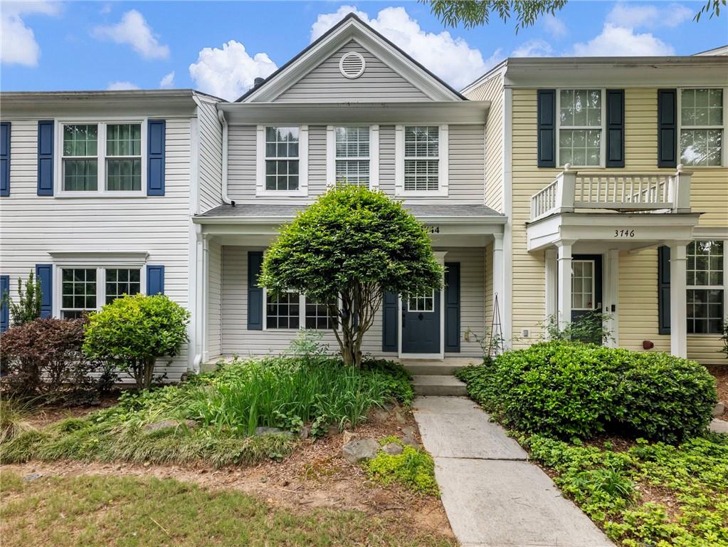 Central townhouse with light gray siding and complementary blue shutters