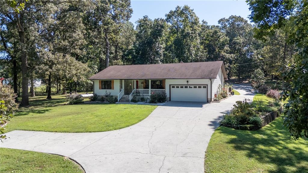 An elegant and inviting county house is nestled 10 minutes from town on alluring and private 5.74-acres. Originally built in 1985 and thoughtfully expanded in 2000, this residence now offers over 3,000 square feet of beautifully curated living space. From the moment you step inside, you’re captivated by the generous family room, where rich, vibrant colors set a tone that is both bold and tranquil. A wood-burning stove adds character and comfort in this gathering space. Off the family room, you’ll find a private en-suite bedroom and a full guest bath. On the opposite side of the family room, the laundry room doubles as a well-designed mudroom, finished with a mirrored backsplash, abundant cabinetry, and a utility sink. The light-filled kitchen is truly the centerpiece of the home, with a soaring vaulted and beamed ceiling, exposed original brick, and a succession of windows and doors that provide natural light and direct access to the courtyard. A professional gas range, solid stone counters, and an oversized center island anchor the space. Located off the kitchen, the primary suite offers a retreat of its own, featuring a separate soaking tub, walk-in shower, and generous proportions. A rear flex room provides versatility as the perfect home office or guest room. Outdoors, the property unfolds into a lifestyle retreat. Over five acres of completely fenced, meticulously maintained grounds are framed by a gated entrance and a canopy of mature trees. A 36x40 workshop with a dock door is ready for projects or hobbies and a 24x30 pole barn with electricity offers additional storage. A gazebo with fire pit and an appointed outdoor kitchen invite year-round entertaining. This home is more than walls and windows—it is a place of genuine beauty, serenity, and purpose. A rare opportunity to enjoy privacy, space, and thoughtful design in one remarkable setting.