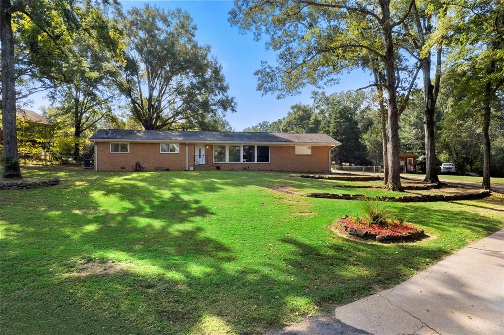 Welcome home to this charming all-brick ranch featuring a large, level, fenced yard — ideal for outdoor entertaining, pets, or playtime! Inside, you’ll love the oversized family room with a cozy fireplace and a bright, separate living and dining area framed by walls of windows that fill the space with natural light. The spacious white kitchen and a convenient pass-through window, making entertaining a breeze. Nestled in a highly convenient location close to shopping, dining, and commuter routes, this home offers both comfort and convenience