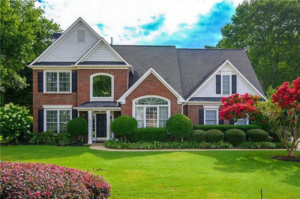 Brick facade residence with a dark asphalt shingle roof