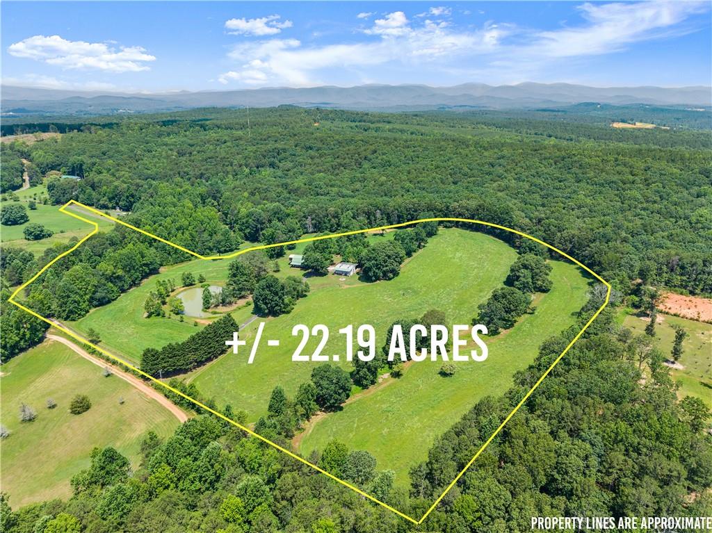 This is the property you’ve been searching for—a remarkable 22 acre pasture estate in coveted Dawsonville. A long, private paved driveway welcomes you to the fully fenced grounds, featuring gently rolling, cross-fenced pasture ideal for horses and livestock. At the heart of the property stands a beautifully appointed 6-stall heated barn. Above the barn, spacious and thoughtfully designed finished living quarters (1,344 sqft) include 2 bedrooms, full bath, kitchen, great room, laundry room, pantry, ample storage, and a charming screened porch—along with a two-car carport for added ease. Access to the living space is available through the barn or via a separate private entrance with minimal steps, offering both convenience and flexibility.
A 30' x 40' heated workshop/metal building is equipped with a 10-foot garage door, water, electricity, and an extended overhang perfect for RV or equipment storage—ready to become your dream woodworking shop, creative studio, or versatile workspace. The grounds also feature a tranquil pond stocked with fish and accented by a graceful fountain, a peaceful creek, and breathtaking sunsets that paint the open fields in stunning colors.
This versatile property offers endless possibilities—whether you’re seeking a private retreat, a hobby farm, family compound, or a place to host gatherings and create lasting memories with loved ones. Conveniently located near GA 400, Northeast GA Hospital, Dahlonega, and Dawsonville shopping. Schedule your tour today!