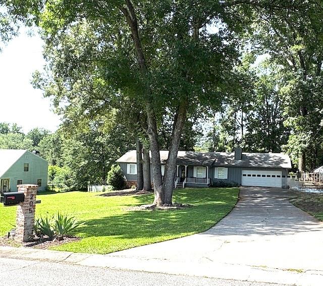 This three-bedroom, two-bathroom ranch-style home is situated on approximately half an acre. It boasts a spacious, modern open floor plan that is exempt from Homeowners Association (HOA) regulations. Additionally, it is conveniently located near dining establishments, shopping centers, and highly regarded educational institutions.
The kitchen is modern and open, featuring a breakfast bar, white cabinets, and stainless steel appliances. It’s a chef’s dream! The great room, with its vaulted ceilings, features a cozy fireplace perfect for chilly evenings. The dining room with a French door leads to a level fenced backyard with a new, completely refurbished back deck, perfect for relaxation and outdoor activities. The primary suite is equipped with his-and-hers closets with an ensuite bathroom. Furthermore, there is a two-car garage with an exceptionally long driveway, ensuring ample parking space for guests. The interior home has been recently painted with designer colors, making it ready for immediate occupancy.
Real estate in this area sells rapidly, so seize this opportunity to make this home yours.