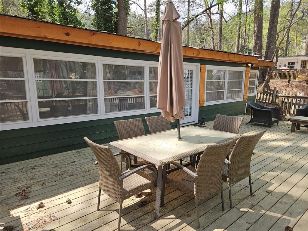 Summertime is Lake time! Charming bungalow in Atlanta Boat Club, a gated community of vacation cottages on Lake Allatoona! This property boasts it's own swimming dock on the Lake, three bedrooms, one and a half full baths, an updated kitchen with granite and newer appliances, dining area, living room that opens to a covered patio, washer and dryer, LVP flooring and an expansive deck with view of the Lake. Atlanta Boat Club leases the property from the Army Corps of Engineers; you are only purchasing the structure and the accompanying swimming dock. The cottage can not be lived in full time nor rented out, per Corps rules. Atlanta Boat Club offers a clubhouse for holiday parties and get-togethers, covered boat storage, a gated entrance, common areas/roads/grounds maintenance.