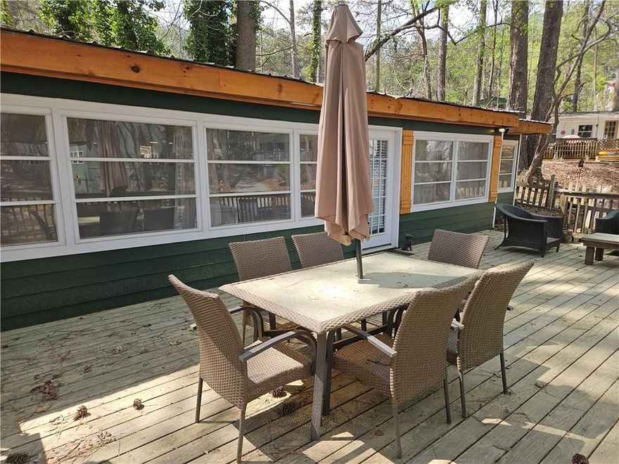 Summertime is Lake time!  Charming bungalow in Atlanta Boat Club, a gated community of vacation cottages on Lake Allatoona!  This property boasts it's own swimming dock on the Lake, three bedrooms, one and a half full baths, an updated kitchen with granite and newer appliances, dining area, living room that opens to a covered patio, washer and dryer, LVP flooring and an expansive deck with view of the Lake.  Atlanta Boat Club leases the property from the Army Corps of Engineers; you are only purchasing the structure and the accompanying swimming dock.  The cottage can not be lived in full time nor rented out, per Corps rules.  Atlanta Boat Club offers a clubhouse for holiday parties and get-togethers, covered boat storage, a gated entrance, common areas/roads/grounds maintenance.