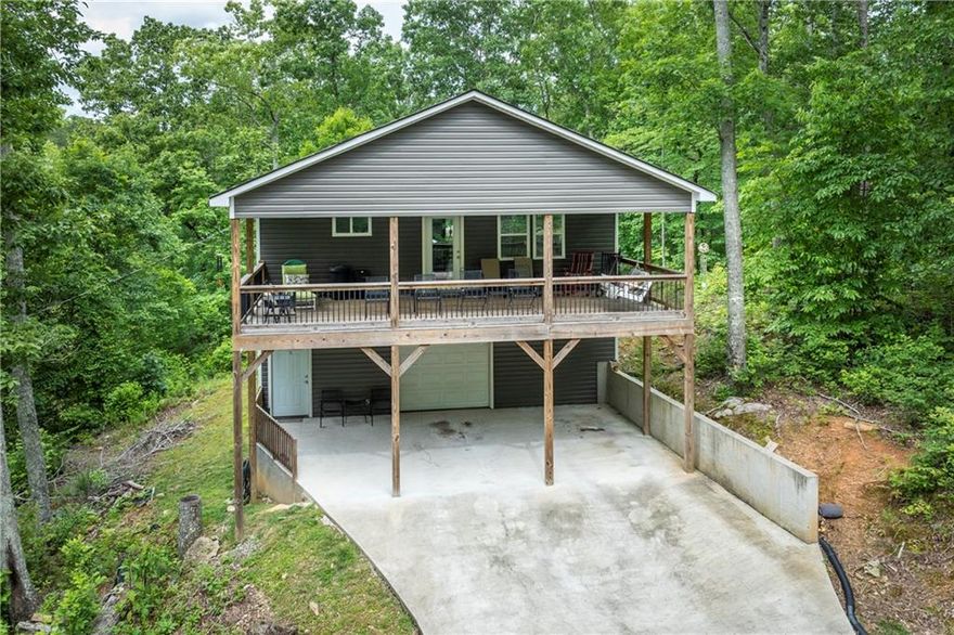 Charming Craftsman-Style Home in Prime South Pickens Location

South Pickens | 2 Beds | 1.5 Baths | Completed in 2021 |  Expansion Potential Actual heated space is 2160 square feet.

Tucked away in a perfect South Pickens setting, this beautifully finished 2-bedroom, 1.5-bath home offers the ideal blend of style, comfort, and potential. Just 10 minutes from the Hwy 515 & Hwy 108 intersection, convenience meets quiet country living.

Step inside to an open-concept great room with cathedral ceilings, recessed lighting, and a cozy electric fireplace all setting the tone for a warm and welcoming space. The kitchen is a showstopper: a large island with French grey tones, floating shelves for a true craftsman feel, crisp white cabinetry, wood countertops, and a custom walk-in pantry with built-in storage.

The spacious master suite is a true retreat, accessed through a frosted glass barn door with a charming penny tile accent. Enjoy a luxurious master bath featuring an oversized tiled shower with rain head and niche, a deep soaking tub, and custom closet space with built-in laundry and organizer system. The master bath also opens onto the private, covered rear porch just perfect for morning coffee or evening wind-downs.

Downstairs, a finished terrace level includes a half bath and a wide, open staircase leading up. With foam insulation, dual HVAC systems, and soundproofed interior walls, this level is ready for your vision to convert it into more bedrooms, a media room, or guest suite with minimal effort. Or enjoy the drive-under garage/workshop with finished sheetrock walls and custom, movable cabinetry.

Extras you'll love:

16' x 30' covered front porch with carport below

Custom finishes and thoughtful upgrades throughout

Foam insulation and dual HVAC for comfort and efficiency

Garage/workshop space easily convertible to living area

This home combines modern upgrades with craftsman character — and room to grow. Don’t miss the opportunity to make this South Pickens gem yours!

 Schedule your private showing today!