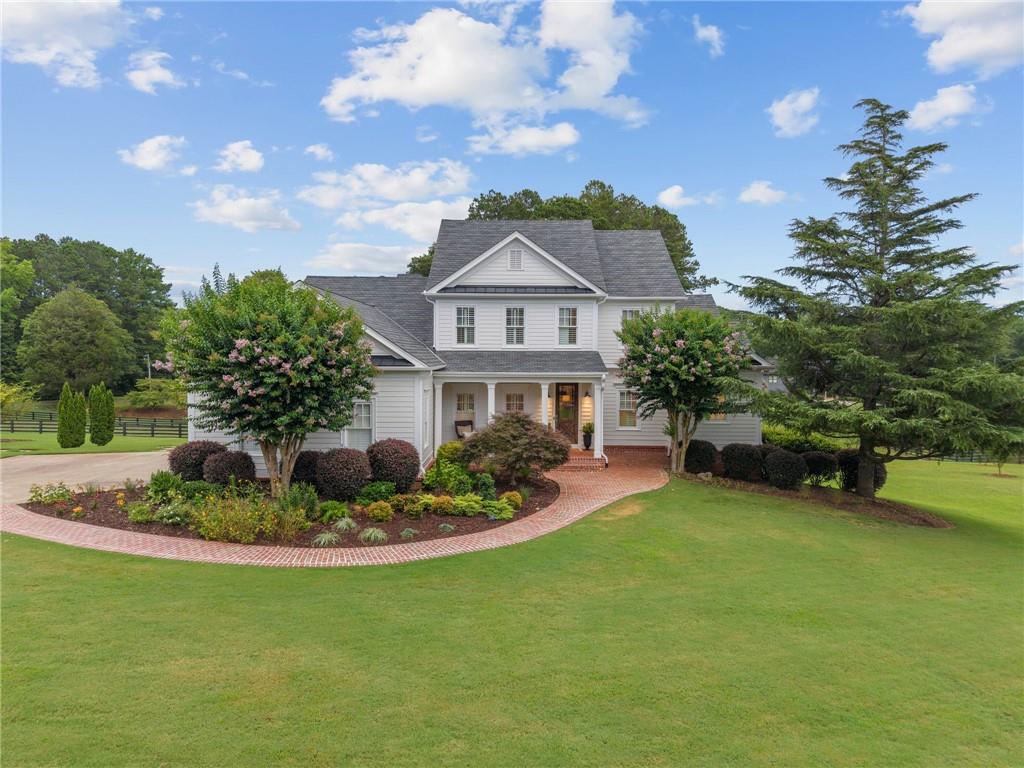 Fully renovated and move-in ready, this stunning Stephen Fuller-designed farmhouse rests on 2+/- private acres just over the Milton line in Cherokee County. Behind the gated entrance, you’ll find a beautifully reimagined home blending modern luxury with classic farmhouse charm.
Recent renovations include a brand-new roof, new windows, fresh exterior paint and stain, and professional landscaping. Inside, enjoy refinished hardwood floors, fresh paint, updated plumbing and electrical, new HVAC, spray foam insulation, and custom cabinetry throughout. The gourmet kitchen features refinished cabinets, marble countertops, updated appliances, a Wolf gas range with pot filler, walk-in pantry, and vaulted fireside keeping room. The adjacent fireside living room offers shiplap walls, a masonry fireplace, and double French doors opening to the expansive screened porch overlooking the private backyard. The primary suite on the main level provides a serene retreat with its own fireplace, exposed brick walls, private porch access, and a luxurious spa-like bath with Carrara marble-topped vanities, freestanding soaking tub, and oversized glass shower with body jets. Upstairs, find three spacious bedrooms with new heart pine floors and two full bathrooms. The finished terrace level is ideal for multi-generational living, with a second full kitchen, living area, bedroom, full bath, and laundry, plus direct access to the backyard. Outside, relax by the pool, dine beneath the pergola, or enjoy the professionally maintained landscaping and lush lawns. Located in the desirable Creekview High School district, this property offers convenient access to Milton, Crabapple, Alpharetta, plus just minutes to Publix, Seven Acres, and Scottsdale Farms. A rare combination of charm, privacy, and modern upgrades. This home is truly turnkey.