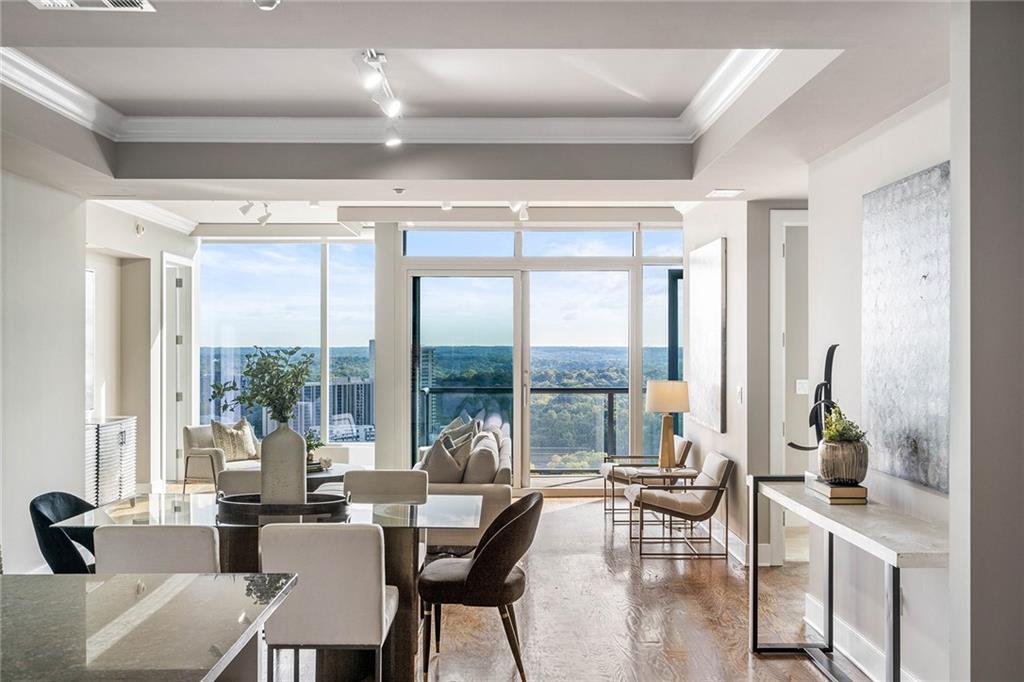 Introducing an exquisite residence at the highly coveted Ritz Residences, nestled in the heart of Buckhead, offering Atlanta's finest shopping and dining opportunities. This splendid condo, situated on the 19th floor, beckons you with an unparalleled eastern sunrise vista that will enchant your every morning. As you step inside, prepare to be captivated by the expansive floor plan adorned with gleaming hardwood flooring, gracefully extending throughout the living space. The kitchen, a chef’s dream, boasts an abundance of storage, a generously sized center island, pristine white cabinetry, and a professional-grade appliance package that includes gas cooking and an integrated cabinetry-paneled refrigerator. Elegance and functionality seamlessly blend as the spacious dining room gracefully spills into the generous family room, effortlessly leading you to a balcony that beckons outdoor enjoyment and relaxation. The primary suite is a sanctuary of tranquility, where spa-inspired luxury awaits in the form of a sumptuous bathroom adorned with dual vanities, a frameless glass walk-in shower, and a separate soaking tub. Every detail has been carefully considered to offer an experience of opulence and comfort. The guest suite, equally spacious, features an additional en-suite bedroom and closet, ensuring that your guests are pampered in style. A convenient powder room stands ready to accommodate your guests with grace and convenience. This condo offers not just the epitome of comfort but also convenience. It comes complete with three parking spaces, one of which is wired for an electric car, and a storage unit. At the Ritz Residences, you are not just buying a home; you are embracing a lifestyle. Resort-quality amenities await your pleasure, including on-site property management, a full-service concierge, porter services, valet parking, a resort-quality pool and spa, an outdoor fireplace with a grilling station, club rooms for social gatherings, a movie screening room, a fitness studio, and even two guest suites for your visiting loved ones. This is not just a condominium; it’s an invitation to live the life of luxury you deserve. Discover a new level of sophistication and comfort at the Ritz Residences in Buckhead.