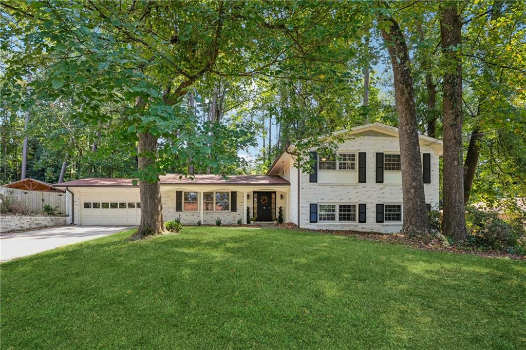 Tastefully updated Embry Hills home on a peaceful dead-end street, set on nearly a half-acre lot with a two-car garage and lime-washed brick exterior. Inside offers four bedrooms upstairs, with a fifth room downstairs- perfect for a secluded office. The renovated kitchen features leather-finish hard marble countertops, new cabinetry, kitchen island, and a stove with built-in air fryer. The primary suite includes a renovated bath with walk-in shower and a separate walk-in closet, while the hall bath has also been updated. The moody den with a fireplace and screened porch add charm and livability. Additional updates include smart thermostats, newer hot water heater, recently serviced HVAC. The fully fenced backyard is spacious, flat, and private. Convenient to I-85/285 with optional Embry Hills Club membership with a pool, tennis, and pickleball courts. Ask the listing agent about the transferable Embry Hills Club membership (no initiation fee).