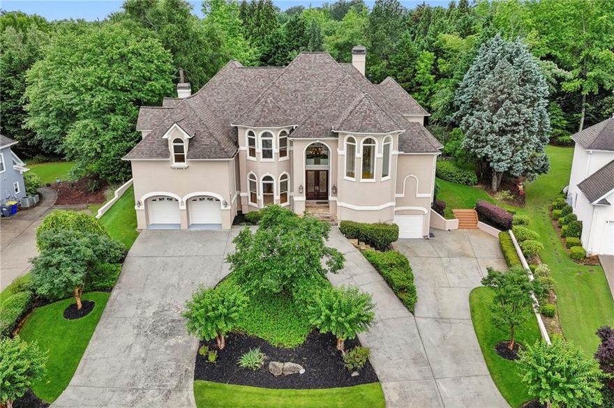 Don't miss out on this incredible offering in the popular Regency Lake neighborhood. Located in one of the top school districts in Cobb County, this wonderful custom built house is truly in turn-key condition and offers a room for every need.  The grand two story entry with 20' ceiling height welcomes you into this beautiful home.  The grand foyer is accentuated by a curved stair case leading to the second floor.  One of the many special features of this truly custom-built house is the extra room off the curved stair case as you approach the second floor.  This custom space as you ascend the staircase offers an incredible area for displaying art, housing a baby grand piano and using as a music room or even utilizing as an incredible home office suite... this special area has to be seen to appreciate just how useful and unique it is.  Entertaining is made easy in this house as all the main rooms (Family room/Keeping room, Grand two story Living room and Dining room) are very spacious.  The two story Grand room with fireplace features a wall of windows overlooking the completely private back yard. The natural daylight throughout this house is very nice. The gourmet kitchen is a chef's dream come true with top of the line appliances and a commercial style six burner gas cook-top with a custom Vent-A-Hood that is restaurant grade in terms of filtering the air.  The breakfast bar is great for a quick meal on the run while the breakfast ‘room’ area adjoins the Family/Keeping room and overlooks the completely private back yard plus the beautiful water fall/koi pond.  As in the Grand room, the Family/Keeping room features an incredible wall of windows for great natural daylight.  The main floor primary suite is literally a "wing unto itself" offering incredible privacy away from everything else.  The primary spa style bath features beautiful Travertine stone.  The primary bath features a walk-in closet that is sure to impress.  The second floor features five secondary bedrooms which are all very spacious and three full baths.  NOTE: one of the secondary bedroom suites upstairs would make a great homework center or home office.  Beautiful hardwood floors are found throughout the first and second floor.  There is a rear stair case too.  The terrace level features the perfect media room option with wiring already in place for your home theatre equipment. There is also a full bath on the terrace level.  There are a total of three garages with two on the main level entering into a mud room area and then a third garage on the lower level which is extra deep with an incredible amount of storage space. The curb appeal is a 10+ with the commanding hilltop setting.  The flag stone stairs leading to the grand entry truly sets the stage for this beautiful custom-built home  This is one offering you do not want to miss out on.