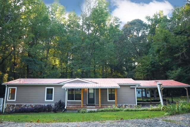 Experience the charm of country living in this 3-bedroom, 2-bath home situated on 2.9 acres, just 15 minutes from shopping, dining, and entertainment! The house has been fully renovated with brand-new cabinets and appliances in the kitchen. Both bathrooms now feature updated fixtures and stylish tiled showers. A new heating and air system has been installed for your comfort. Relax on the spacious back deck and take in the serene views of the wooded lot, complete with a natural spring and a stunning variety of flowers and shrubs. There are 2 extra storage buildings and a new dog pen on the property.