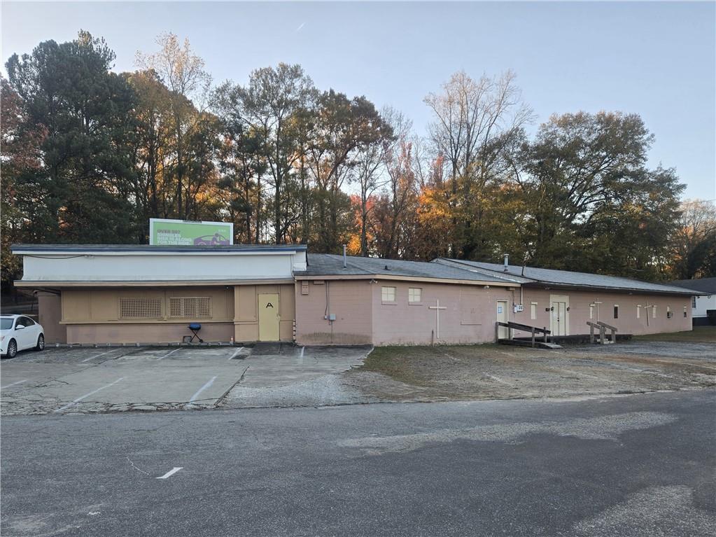 Endless opportunities with this cash generating property. It is currently separated as two units with well lit 100+ parking spaces. The larger unit at 4500 sf has 3300 sf of open space with cement floors as well as an office and kitchen. The second unit at 1000 sf provides a highly visible storefront environment. Both units are vacant since January 1, 2025. The property generates additional cash flow being leased as parking for Lakewood Amphitheater and an on-site billboard. In previous years, this property generated more than $30,000 in annual revenue.