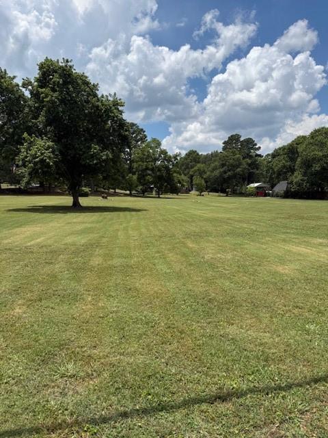 Property located at corner of Etowah Dr and Indian Trl. Total of 4.07 acres in the heart of Cartersville. Ideal for development on corner property. Natural gas, sewer, public and public water at property. Located one block from Dillinger Park. Fronts two county roads. Two cleared acres in front and additional two acres with house and rear buildings. Brick three bedroom two and one 1/2 baths. Living, dning, den, kitchen, glassed sunroom with brick floor. Has hardwood, ceramic tile and carpet flooring. Buildings in rear rented on month to month basis. Property must be sold as a whole. Chandeliers in dining and foyer do not stay. Owners licensed real estate brokers in the state of Georgia.