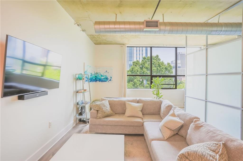 Come live in the bustling Midtown/Downtown Centennial Park neighborhood in this beautiful loft that will not disappoint! Enjoy expansive views from this beautiful loft that will not disappoint! Enjoy expansive views from your sofa of Midtown or go to the roof top terrace to see the entire city. Walkable to all things Downtown, this location is super pedestrian friendly with the ability to walk to loads of dining options, Mercedes Benz Stadium GA Aquarium, State Farm arena, and so much more. This home features new hardwood floors, freshly painted, extra large walk in closet, deeded storage space that’s climate controlled, deeded parking, and a full service concierge. This boutique loft building is all about location!