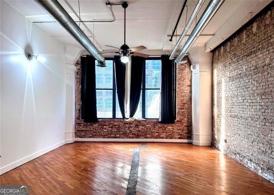 Industrial looking Condo in the heart of Atlanta! This expansive 2-bedroom, 1.5-bathroom loft, located in the historic Kessler City Lofts, boasts 1500 sqft of living space. With its towering 14-foot ceilings. As you step inside, you'll be greeted by gorgeous original wood floors and exposed brick accent walls that exude a historic yet contemporary feel. The large main bedroom offers plenty of space. The loft's architectural elements and designer details make it a truly unique living space. The open floor plan is perfect for entertaining, with an open concept kitchen and living space ready for your personal touch. Natural light floods the space through the oversized windows, offering breathtaking views of the charming cityscape below. The building's common areas include a rooftop deck with unmatched sunset views, a fully equipped gym, and a community rooftop garden managed organically. Please note that this unit does not include a parking space but an ideal walk to Centennial Park, Underground Atlanta, Five Points Marta Station, Georgia State University, Mercedes Benz Stadium, State Farm Arena, Atlanta City Hall, and countless galleries and restaurants. Sold as is, this loft represents a rare opportunity to own a piece of Atlanta's rich history while enjoying the vibrant energy of downtown living. The unit is being rented currently. Lease expires in January 2026. Don't miss your chance to make this extraordinary loft your new investment that can be turned into your home! HOA FEE- $632.48 PER MONTH INCLUDES- HIGH-SPEED AT&T FIBER INTERNET, TRASH, CONTROLLED ACCESS, ROOFTOP GARDENER, COMPOSTING
