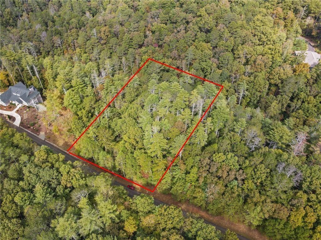 Build your home on this 1.44 Acre wooded lot with natural privacy while enjoying the soothing sounds of Fausett Creek just below passing along the back lower end of the property. Located in the gated community of Mountain Creek Hollow with amenities including a creek-side pavilion with fireplace and picnic tables, underground utilities, a covered bridge, stocked trout pond, community garden, water wheel and walking trails. Fausett Creek is a wide creek featuring many small, picturesque waterfalls and several trails to walk. This community has stunning landscaping with paved roads and underground utilities. Full Survey has been completed and all 4 point of the lot have been marked with red flags. Embrace the tranquility and seclusion of this mountain getaway community and within 10 minutes to shops and restaurants in Ellijay. Community is ideally centered between both Ellijay and Jasper. Look for marker for Lot #122. *Please note: No Short-Term Rentals Allowed. Min build requirement 2000sqft, main level min 1400sqft on perm foundation. After build commencement then have 12 months to complete. Underground public water and electric, need only septic.