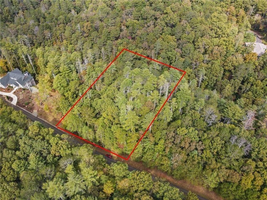 Build your home on this 1.44 Acre wooded lot with natural privacy while enjoying the soothing sounds of Fausett Creek just below passing along the back lower end of the property. Located in the gated community of Mountain Creek Hollow with amenities including a creek-side pavilion with fireplace and picnic tables, underground utilities, a covered bridge, stocked trout pond, community garden, water wheel and walking trails. Fausett Creek is a wide creek featuring many small, picturesque waterfalls and several trails to walk. This community has stunning landscaping with paved roads and underground utilities. Full Survey has been completed and all 4 point of the lot have been marked with red flags. Embrace the tranquility and seclusion of this mountain getaway community and within 10 minutes to shops and restaurants in Ellijay. Community is ideally centered between both Ellijay and Jasper. Look for marker for Lot #122. *Please note: No Short-Term Rentals Allowed. Min build requirement 2000sqft, main level min 1400sqft on perm foundation. After build commencement then have 12 months to complete. Underground public water and electric, need only septic.