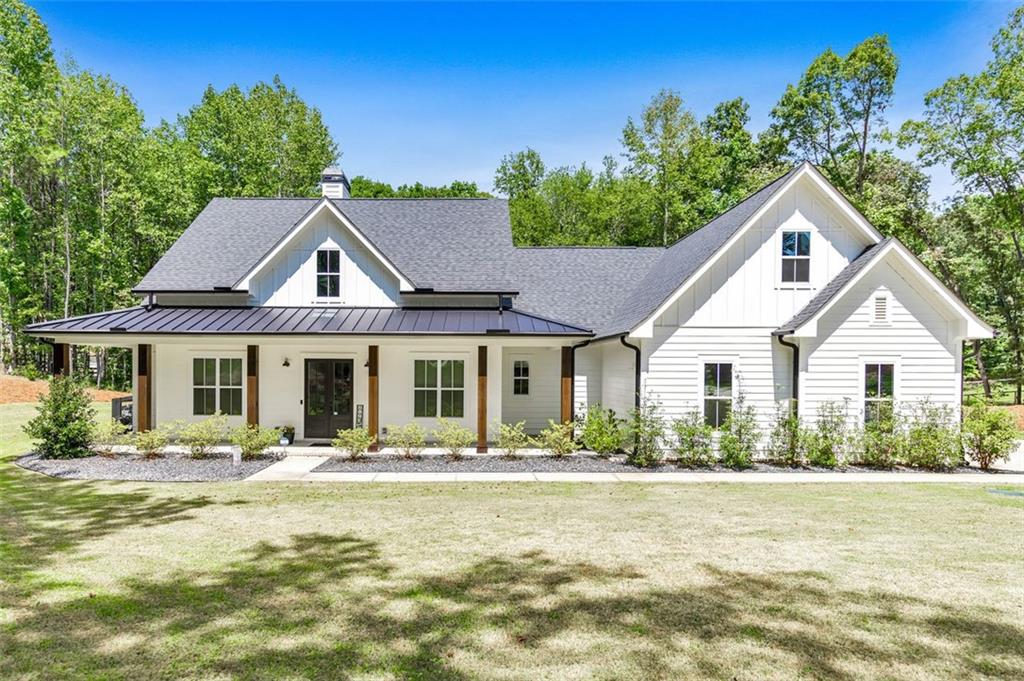 Looking for a home that checks all of your boxes? Look no further! Welcome to this stunning 2023-built modern farmhouse, offering 4 bedrooms and 3 baths on a picturesque 1.5 acre lot in a prime Woodstock location. From the moment you step onto the charming rocking chair front porch, you’ll feel right at home. Inside, the open-concept design is filled with natural light, showcasing a bright and airy living space that’s perfect for both everyday living and entertaining. The chef’s kitchen is a true showpiece with an expansive island, quartz countertops, stainless steel appliances, a farmhouse sink, and a large walk-in pantry. An office sits just off the main living area, providing a quiet space to work from home. The main-level primary suite is a luxurious retreat with a spa-like bath boasting a double shower and dual vanities. The oversized walk-in closet is a dream and connects directly to the laundry room for added convenience. Two additional main-level bedrooms share a beautifully designed hall bath with a double vanity, while a versatile flex room with a dog door to the backyard adds extra function. Upstairs, a private bedroom and full bath create the ideal suite for teens, guests, or extended family. Thoughtful details include 8-foot solid core doors on the main level, soft-close cabinets/drawers throughout, a tankless gas water heater, and a washer and gas dryer included. Outside, the expansive covered back porch and extended patio overlook the level, fenced backyard, providing the perfect backdrop for weekend barbecues, playtime, or simply relaxing while kids and pets enjoy the space. Blending modern luxury with timeless farmhouse charm, this home is designed for comfort, style, and lasting memories. With its incredible features and inviting spaces, it’s a place you’ll be proud to call home for years to come!