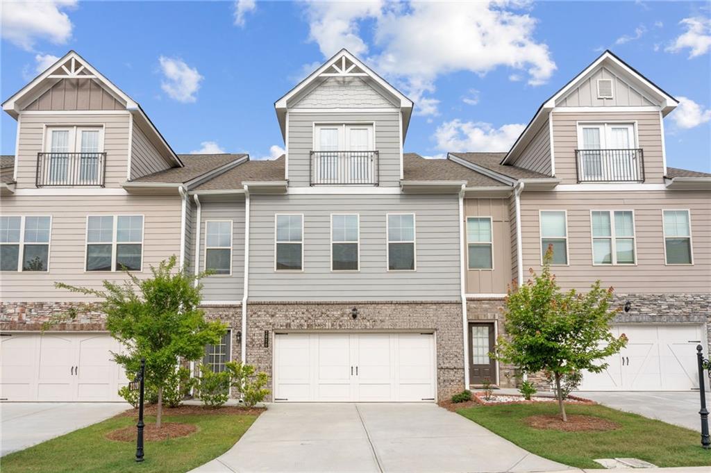 MOVE-IN-READY! Multi-level townhome featuring a mix of horizontal siding and brick accents
