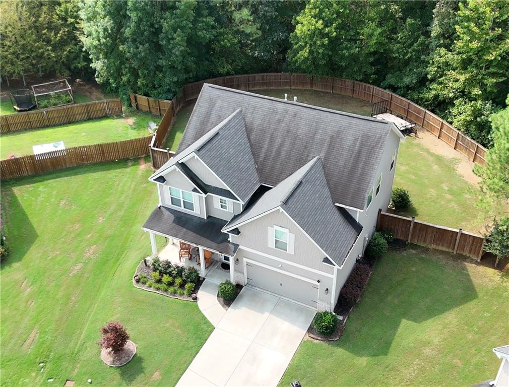 Nestled on a quiet cul-de-sac in Adairsville, this four-bedroom, two-and-a-half-bathroom residence offers a blend of contemporary style and functional living spaces. Constructed in 2020, the home spans 2,336 square feet on a generous .24-acre lot, providing a spacious and private retreat. The exterior presents a modern craftsman aesthetic with a covered front porch that provides an ideal spot for enjoying a quiet summer morning. Inside, the main level features an open floor plan that seamlessly connects the living areas. A dedicated office space at the front of the home offers a quiet place for work or study, ensuring productivity is within easy reach. The heart of the home is a spacious kitchen, complete with white cabinetry, granite countertops, and a large center island that provides additional seating and prep space. The kitchen flows effortlessly into the living room, where a cozy fireplace serves as a central point for gathering with guests. The rich hardwood flooring throughout the main level adds a touch of sophistication and is easy to maintain.
Upstairs, the owner's suite is a true sanctuary. It features a tray ceiling, plush carpeting, and large windows that bathe the room in natural light. The private bathroom includes a dual-sink vanity, a separate soaking tub, and a standalone shower, creating a spa-like atmosphere for unwinding after a long day. Three additional bedrooms provide ample space for guests or can be adapted for hobbies, a home gym, or a media room. The shared full bathroom also features a dual-sink vanity, offering convenience and plenty of counter space. The laundry room is also conveniently located on the second floor, simplifying daily routines.
Step outside to the expansive, level backyard, which is fully fenced for privacy and security. The covered patio is perfect for summer barbecues and entertaining, offering a shaded space to enjoy the warm weather. The sizable yard provides a blank canvas for gardening, a playset, or simply enjoying the outdoors. With no rear neighbors, the backyard feels even more secluded, offering a peaceful backdrop for outdoor activities. The two-car garage provides secure parking and additional storage. Located in a tranquil community with easy access to local amenities and major roadways, this home offers both a peaceful residential setting and convenient connectivity. This property is a rare find, combining modern design, a practical layout, and a prime location.
To experience the unique appeal of this property, please contact us for a private showing.