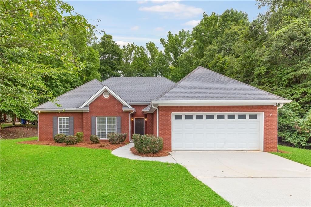 Welcome to this beautifully updated, step-less four-sided brick ranch offering timeless curb appeal, modern updates, and a peaceful setting conveniently located near I-20 for an easy commute while still feeling tucked away from the hustle and bustle. With a two-car and extended parking pad you'll have ample parking for boat, RV, and more. Inside, all updates are less than two years old, including new flooring, updated appliances, fresh paint, modern lighting throughout, and more. The inviting foyer opens to a formal dining room and leads into the vaulted family room, anchored by a floor-to-ceiling ship-lap gas fireplace, a warm and welcoming focal point. The galley-style eat-in kitchen features stainless steel appliances, a subway tile backsplash, a casual dining area, and direct access to the back patio, making indoor-outdoor living a breeze. A separate laundry room with built-in storage cabinets adds to the home’s functionality. The primary suite boasts double tray ceilings, a sitting room with private patio access, a jetted tub, double vanity, and generous closet space. Two additional bedrooms and a full bath complete the well-designed floor plan. Step outside to your private backyard oasis with wooded views, offering the perfect blend of nature and possibility. An extended patio and pathway create an ideal space for a fire pit, cafe lighting, for a cozy seating area, just in time for crisp fall evenings. And with no HOA, you have the freedom to design the backyard of your dreams!! Located near grocery stores, shops, dining, schools, walking trails, and recreational facilities. This home offers the best of both convenience and tranquility. A rare find so don’t miss your chance to call this updated ranch your own!