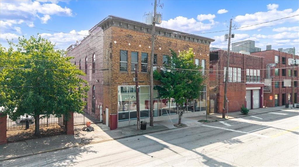 Discover a truly one-of-a-kind residence in Castleberry Hill’s historic arts district - one of the largest lofts in the iconic Peters Street factory conversion. This 3-story corner unit is filled with character and modern convenience, offering 30’ ceilings, oversized palladium windows, and original exposed brick and heart pine floors that showcase its industrial charm. Step inside through a gallery-style foyer and into a dramatic open layout, where natural light pours through soaring windows and highlights the spacious living and dining areas. On the main level, a custom wine-barrel chandelier anchors the separate dining space, while the updated kitchen features granite countertops, stainless steel appliances, breakfast bar, and pantry. The main level overlooks a cozy living room, creating an open vertical floor plan. The top-level primary suite feels like a retreat, complete with a spa-inspired ensuite bathroom complete with double vanity, step in shower and free standing tub. A second bedroom on the lower level doubles as a home office, guest room, or fitness space, with a full bathroom for flexibility. Secure entrances, private covered parking, dog park, and a walkable neighborhood just steps from shops, restaurants, and Mercedes-Benz Stadium makes urban living effortless. Recent upgrades include a brand-new HVAC system and newer water heater. A transferable, fully integrated Google Smart Home system connects a Nest thermostat, Yale lock, multicolor Philips Hue lighting, window shade and ceiling fan controls, and smoke/CO2 detectors. This is not just a loft - it’s a lifestyle in the heart of Atlanta’s most vibrant historic district.