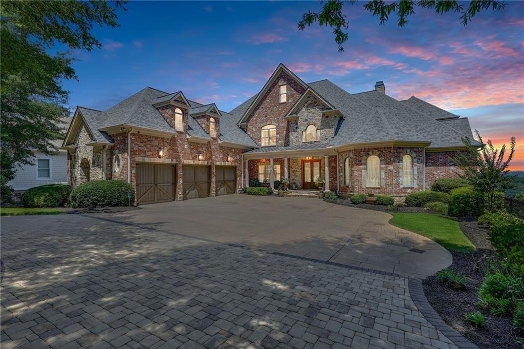 Harbour Point Yacht Club and Marina! A rare opportunity to own a truly exceptional Lake Lanier estate, offered fully furnished with elegant, high-end pieces and ideally positioned on one of the most desirable lots on the lake. Located within the prestigious, gated Harbour Point Yacht Club and Marina community, this custom-built home showcases sweeping sunset views over Lake Lanier and the Blue Ridge Mountains from three expansive verandas. Designed with both luxury and lifestyle in mind, this four-level estate features an elevator, two home offices, and a heated pool and spa. A deeded boat slip is included, offering seamless access to lakefront living. The main level welcomes you with a grand two-story foyer and living room, formal study, and refined dining room. A brand-new custom chef's kitchen is outfitted with a 60" Wolf range with double ovens, Sub-Zero refrigerator, Miele coffee station, and an oversized walk-in pantry. The cozy keeping room features a stone fireplace, and the spacious primary suite includes a spa-like bath and newly designed California Closets. The terrace level is an entertainer's dream, complete with a wine cellar and tasting room, full kitchen and bar, gathering room with fireplace, 10-seat home theater, steam shower, sauna, and private guest suite. The lower poolside level adds even more space for entertaining with a second full kitchen, additional ensuite, gathering room, game room, and fitness room-all opening to the pool and landscaped, fenced backyard. Additional features include a three-car garage plus a dedicated Harley garage, a newly resurfaced pool with cabana, and numerous recent upgrades including a Crestron Smart Home system, updated irrigation, fire sprinkler and security systems, and tankless hot water.