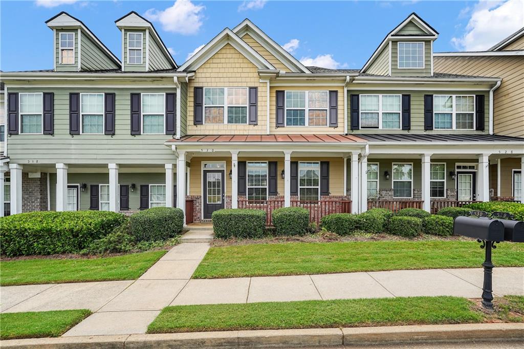This beautifully renovated 2-story townhouse blends modern sophistication with timeless character in every detail. A welcoming rocking-chair front porch sets the tone, opening to an inviting interior highlighted by graceful arched doorways, detailed crown molding, upgraded designer lighting, and durable LVP flooring that flows seamlessly throughout the main level. At the heart of the home, the gourmet kitchen impresses with a stylish breakfast bar and a full suite of high-end stainless steel appliances that will remain with the property. Designed for effortless entertaining, the kitchen overlooks the spacious family room, creating a warm and open gathering space. The primary suite is a luxurious private retreat, complete with a tray ceiling and a covered balcony ideal for quiet mornings or evening relaxation. The recently renovated spa-inspired bath offers dual quartz vanities with chic gold-accent lighting, oversized 24”x12” ceramic tile flooring, and a frameless glass shower with designer subway tile and an elegant shower wand. A spacious walk-in closet enhances both function and style. Generously sized secondary bedrooms, along with thoughtful enhancements throughout, ensure comfort for family and guests alike. Ideally located just minutes from vibrant Downtown Woodstock, the Outlet Shoppes at Atlanta, and the Town Lake area, this move-in-ready residence also offers the advantage of being within some of the most sought-after school districts in Cherokee County.