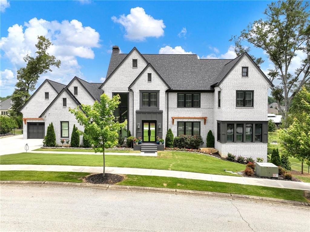 Welcome to Chateau Life! Nestled on a pristine 1.42-acre double cul-de-sac lot, this exquisite residence is the perfect blend of timeless traditional elegance and modern functionality. From the moment you arrive, the stately curb appeal and meticulously landscaped grounds set the tone for the exceptional living experience within.
Step through the double glass entry doors into a sun-drenched interior where white oak hardwoods, beamed ceilings, and walls of windows fill the open-concept floor plan with warmth and natural light. The two-story Great Room showcases a gas fireplace flanked by built-in cabinetry and seamlessly transitions to a vaulted covered porch via sliding glass doors—perfect for indoor/outdoor living and entertaining.
The gourmet kitchen is a chef’s dream, equipped with a professional-grade appliance package, a large center island, and direct access to an expansive walk-in pantry that doubles as a convenient buffet service area. Barn doors open to the formal Dining Room, offering serene views of the beautifully manicured grounds.
The main-level primary suite is a private retreat featuring tray ceilings, a custom walk-in closet, and a spa-inspired bath with dual vanities and a luxurious wet room complete with a soaking tub and oversized shower. A secondary main-level room with a glass door functions as a bedroom, home office, or den. Additional main-level highlights include a powder room, a spacious laundry room with a built-in pet grooming station, a drop zone, and an oversized 4-car garage equipped with car lifts—ideal for the automotive enthusiast.
Upstairs, an open landing leads to a large loft with built-in window seating—an ideal lounge or study area. Three generously sized secondary bedrooms complete this level, two of which feature vaulted ceilings and unique loft areas—perfect hideaways for children or guests.
The finished terrace level expands the home's versatility, featuring a second kitchen and an open-concept family/media room that opens to a covered patio overlooking the saltwater pool and spa. And two bedrooms on this level makes it an ideal in-law or nanny suite.
The fully fenced lot is a rare find—offering privacy, scenic green space across the street, and a tranquil wooded creek along the perimeter. Mature landscaping and strategic tree placement provide exceptional buffering and seclusion.
Located within the prestigious Chateau Elan gated community, residents enjoy access to three 18-hole golf courses, a Junior Olympic-sized pool, fitness center, tennis and pickleball courts, indoor gymnasium, sports fields, playground, and dog park. The neighborhood is both gated and golf-cart friendly, with access to the Braselton LifePath connecting residents to nearby restaurants, parks, shops, and the Chateau Elan Resort, Winery & Spa.
Home is located in the op-rated Gwinnett County’s Mill Creek school cluster and surrounded by esteemed private school options, this home also offers unbeatable convenience to I-85, Lake Lanier, Gainesville, and the University of Georgia in Athens.
Come live the Chateau Life in the ATL!