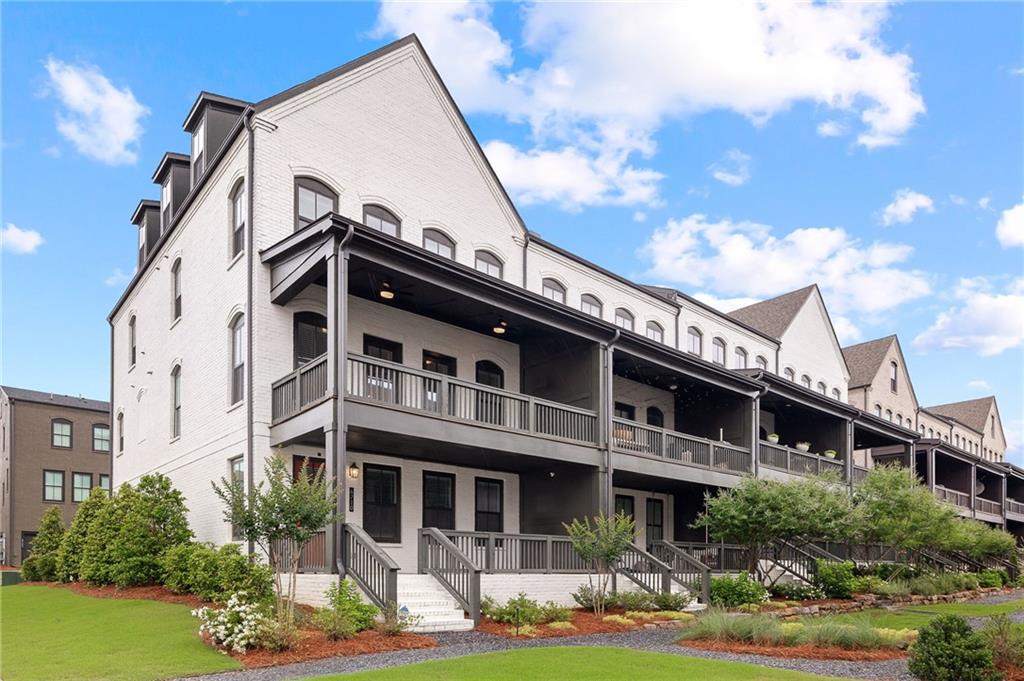 Welcome home to this stunning end-unit townhome located in the highly sought-after Halcyon community in Alpharetta, GA. Just a few years new, this 4-bedroom, 3.5-bath residence offers the perfect blend of modern luxury and convenience. This 22 foot wide floorplan is spacious and open. Ideally situated near the community pool and easy access to the Big Creek Greenway (a 45s walk from your doorstep), making it walking distance to Halcyon’s premier shopping, dining, and entertainment. Enjoy views of the beautifully landscaped courtyard from the spacious front porch. Inside, the entry-level foyer welcomes you with a bright and open layout that includes a versatile bedroom, office, or flex space with a full bath, and access to the attached two-car garage with storage space and a private driveway with ample parking. Upstairs, the main living level is filled with natural light and features an open-concept floor plan. The chef’s kitchen is equipped with stainless steel appliances, quartz countertops, a large island with seating, and an expansive dining area perfect for gatherings. The fireside family room opens to a generous covered deck, ideal for entertaining. This level also includes a half bath, a dry bar, a large walk-in pantry, and a built-in business/flex center. On the top floor, you'll find a luxurious primary suite with a trey ceiling, a spa-like bath with dual vanities, and a tiled frameless shower. Two additional secondary bedrooms, a full bath, and a convenient hallway laundry area complete this level. An elevator shaft is already installed for future elevator access if desired. Community amenities include a pool, clubhouse, expansive green spaces, and a large shared courtyard—all with direct access to the Big Creek Greenway. Enjoy Forsyth County taxes with an Alpharetta address. This home is a rare opportunity in one of Alpharetta’s most vibrant and walkable communities.