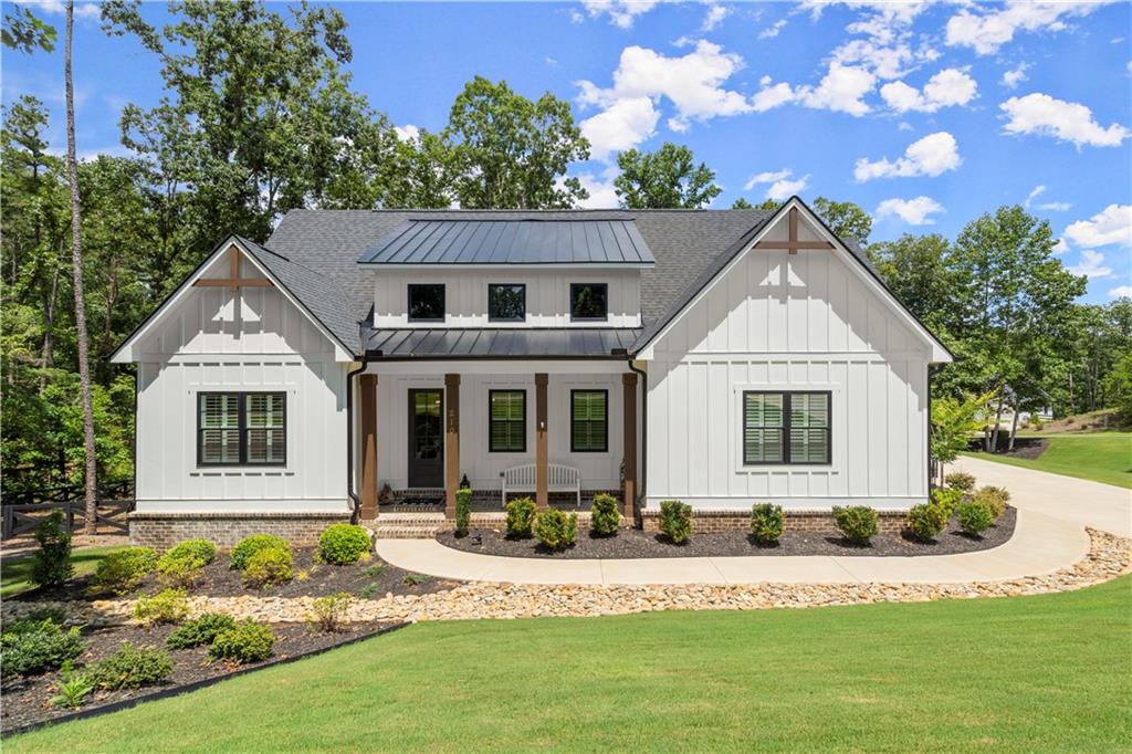 Welcome to 210 Birmingham Road – where luxury living meets the relaxed elegance of North Georgia. Seller has been relocated, home is priced to sell. Located in the gated community of The Tate Reserve, this 3 bedroom / 3 bath modern farmhouse-style ranch on a finished daylight terrace level sits on a beautifully wooded 1.6-acre lot designed for privacy, entertaining, and beautiful views. This flexible floor-plan features 10-foot ceilings, 8-foot doors, coffered ceilings, and an open-concept layout with natural light. The bright chef’s kitchen features 42” soft-close cabinetry, granite countertops, a spacious center island, 5-burner gas cooktop, upgraded hood vent, stainless appliances, and a large walk-in pantry with wood shelving. The primary suite on main offers a spa-style retreat with double granite vanities, a soaking tub, a frameless walk-in shower, and an oversized walk-in closet. Two additional bedrooms and a full bath are tucked away on the main floor for privacy, along with a large laundry room and mudroom entry off the garage. Step outside to a screened-in porch overlooking the fenced backyard and an outdoor kitchen, perfect for dining alfresco or entertaining. The finished daylight basement includes a theatre room wired for sound, a large rec room stubbed for a bar or kitchenette, a flex space with a full finished bathroom, creating ideal space for multi-generational living, guest quarters, or an in-home office. There's also unfinished space for future expansion or storage. Seller has invested $150,000+ in thoughtful upgrades including a whole-house Generac 26kW generator, epoxy-coated garage floors, a functional finished basement, built-in grilling station inside a cozy screened in deck, and several other smart post-closing enhancements. Located just minutes from Hwy 372 and I-575 (Exit 27), this home offers quick access to downtown Ball Ground, Canton, Woodstock, and even into Atlanta, while still enjoying the charm of a small-town lifestyle. Gibbs Gardens, North Georgia wineries, hiking trails, and scenic drives are all within easy reach. The community itself is active and welcoming, with social events, clubs, and even neighborhood wine tours that make everyday living feel like a getaway. Don’t miss this opportunity to get exceptional value in today’s market! Schedule your private showing today.