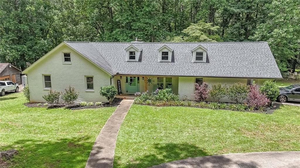 This beautifully maintained and update painted brick ranch offers 4.2 acres of a private tranquil setting with a premier location. Keep the home and build on or build new. Only 3 miles from the Birmingham Boutique Publix shopping center and highly desired Creekview school district. The 3/4-bedroom (one bedroom is a bonus room), 3-bath home features all brand new trim throughout, updated windows, hand scraped hardwood floors in all rooms, and an open living space ideal for entertaining. Owners’ suite has newer ensuite with separate oversized tub, shower, custom cabinets, and his/her walk-in closets. The kitchen has granite countertops, stainless steel appliances, double oven, and a ton of cabinets and storage. Mud Room with custom storage and pantry cabinets. Spacious laundry room with sink, custom cabinets, and storage. Two upstairs bonus rooms and a walk-in attic. Workshop has power and water; could be converted to a barn. Power coming to home has been upgraded to 400 amp. Full basement is unfinished with a bath and fireplace. Property lays nice and full of large, beautiful hardwoods. Owner is a License Real Estate Agent in Georgia.
