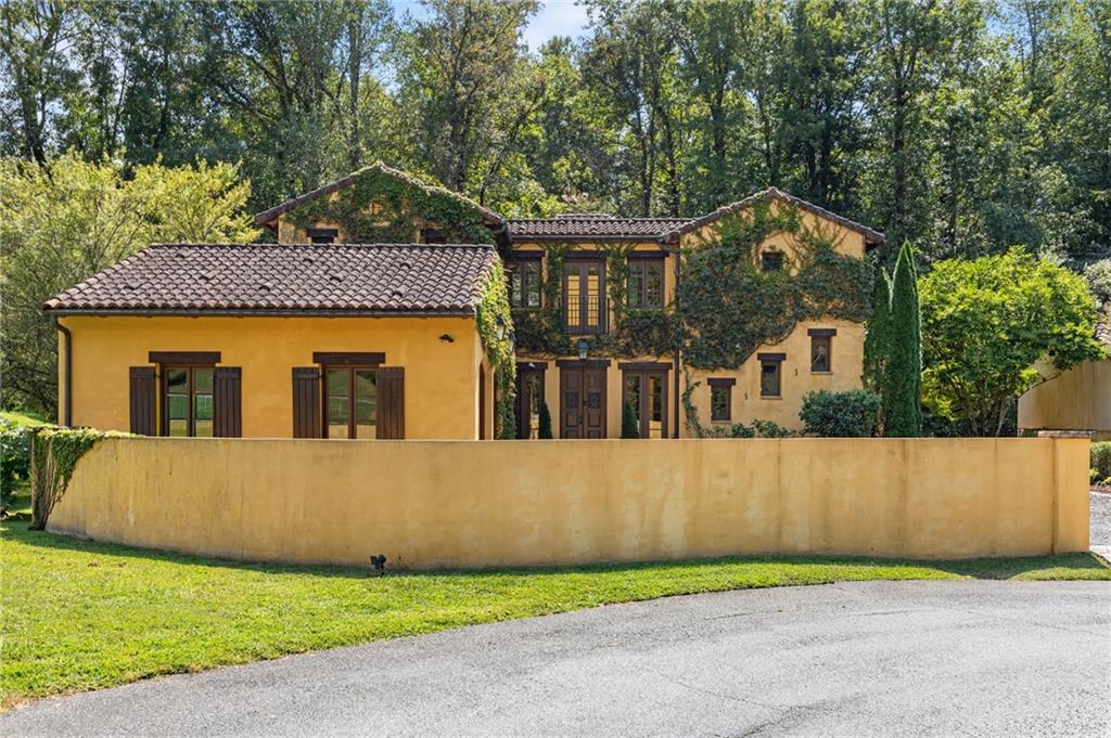 Why buy a vacation home in Italy when you can live the dream in the foothills of the North Georgia Mountains? Tucked within an exclusive enclave of Italian-inspired residences inside the prestigious Montaluce Winery & Estates, this 4-bedroom, 4-bath Tuscan villa is a romantic getaway blending elegance, character, and modern comfort.
This exquisite home is true to its culture. Upon arrival your eyes are met with the home painted in the warm, sun-kissed hue of Tuscany. The attention to every detail of the time period is showcased with authentic terracotta roof, a home wrapped in lush climbing ivy—this three-story residence feels as if it was lifted straight from the hills of Umbria.
Inside, you’ll find gracious gathering spaces highlighted by three fireplaces, a gourmet kitchen with a large island, and seamless flow to expansive terraces and loggias overlooking the vineyards and mountains. Each bedroom offers private retreat and spa-inspired baths, while every detail whispers of timeless charm. The handcrafted detailing radiates sophistication with authentic tile and wood flooring, and eye-catching ceilings with custom beams.
Outdoor living is at the heart of this home. A charming courtyard open to the warm sky offers its own fireplace and creates the perfect setting for gatherings, and enjoying your favorite wine from one of two restaurants on site. Montaluce Winery & Restaurant or Trattoria di Montaluce - a more casual Italian dining experience.
The enclave of Tuscan homes enjoys a warm community life and amenities. The community offers a lifestyle unlike any other with resort style pool, views of the vineyard, a bocce ball court, and riverside trails to leisurely explore. Whether it’s sipping estate wine on the terrace, strolling vineyard paths, or entertaining guests by firelight, this villa delivers the best of European living—without a passport.
All within easy accessibility to parks, lakes, mountains, shopping, an hour from Ellijay/Blue Ridge and minutes from historic Dahlonega, yet worlds away from ordinary life.
****Highlights****
This amazing home was built as the Showcase Home, with custom upgrades not found in others at the time.
**4 bedrooms, 4 full baths across three levels**
**Authentic Tuscan architecture with tile roof, beamed ceilings, and custom millwork**
**Three fireplaces, tiled floors and wooden floors**
**Hot tub and outdoor kitchen**
**Courtyard with outdoor fireplace, terraces with panoramic views**
**Located in the prestigious Montaluce Winery & Estates with two on-site restaurants and private event space for entertaining**
**Private setting, amazing views**
Your Italian villa awaits—closer than you think.