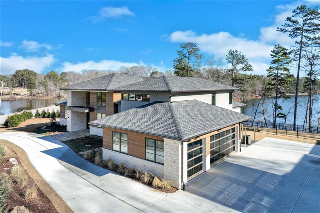 Discover Crownview: Lakeside Luxury Redefined. Experience the pinnacle of upscale living at Crownview, AR Homes newly unveiled model home, set on the serene shores of Lake Lanier in Chattahoochee Estates in Northeast Georgia. With two miles of sweeping lake views and modern detailing, this fully furnished residence offers an unrivaled lifestyle in one of the most desirable communities in America. Step into an expansive, open-concept main floor designed for effortless living. The gourmet kitchen and casual dining area flow seamlessly into a great room adorned with walls of glass, inviting natural light and offering uninterrupted views of the lake. The hidden away scullery pairs perfectly with our kitchen and gives more cabinetry, appliances, prep and cooking space. Large sliding doors open to a generous covered porch, where indoor sophistication meets outdoor serenity. Crownview boasts 5,700 total square feet of meticulously crafted space, featuring: 4 Bedrooms & 4 Bathrooms: The owner suite is designed with a spa-like touch, providing luxury and comfort. Elegant Living Spaces: A double-sided fireplace creates a warm, inviting atmosphere between the den and great room. Versatile Layout: The main level is perfectly suited for day-to-day living, while a private second level offers a secluded retreat for guests complete with a bonus room. Thoughtful Amenities: Enjoy walk-in, climatized attic storage, a three-car garage, a state-of-the-art wet bar, and controlled access delivery room Resort-Style Outdoor Living: The lake living patio comes equipped with automatic screen panels, a cozy fireplace, and ceiling heaters for year-round enjoyment. A plunge pool overlooks the tranquil lake, and the gentle sound of a neighboring waterfall flowing from Lake Knickerbocker to Lake Lanier creates a soothing backdrop to your evenings. Whether you're relocating from another state or seeking a fresh start in a vibrant community, Crownview delivers an unparalleled combination of luxury, stunning views, and exceptional design crafted for those who demand the very best. Schedule Your Private Tour Today and Discover the Magic of AR Homes Crownview.