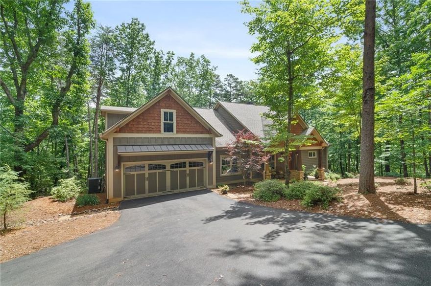 WELCOME HOME! to your beautiful 4 BR- 3 Full bath Mountain design home offering an open floor plan with numerous built- ins and countless upgrades throughout.This home was custom built 7 years ago and shows like a model encapsulating every fine detail you’d ever want in this very charming and like new home. This lovely home has a gentle sloped driveway and is situated on a quiet wooded cul-de-sac. You will enjoy the beauty of the hardwood floors on the Main level as well as the Family Room’s cathedral ceiling with exposed wood beams and a stone fireplace. The Bose surround sound system will provide added entertainment to your television and music enjoyment. In the Great room you will find a wine/ beverage bar area and a coffee station in the kitchen both with quartz countertops and cabinetry. The Kitchen has upgraded KitchenAid appliances and an oversized breakfast bar for snacking or dining.
Off of the kitchen, you will find another casual dining space that can also serve as a keeping room complete with a stacked stone fireplace to provide warmth and ambience to our Big Canoe cool evenings. This home provides a very unique feature in offering a total of 3 BR’s on the Main level of which one is an expansive Master Suite along with an upstairs 4th BR with in- suite access and an exercise/ flex space. Through the dining doors, you will enjoy the newly added pergola covered area with barrel fire table as well as an open dining/ grill deck.  The backyard has direct access to the paved walking trails and provides a convenient short walk or bike ride to the Wildcat Pool and sports activities as well as the dog park. Also, from the backyard you can access the walk under dry storage area that could be utilized for future expansion, if so desired. Some added unseen benefits of this home includes a Wildlife Exclusion Barrier with guarantee and gutter guards.  Also, a unique feature is a German technology specialty “ self  clean” exterior paint. YOU ARE SURE TO LOVE THIS HOME, BUT DON’T TAKE MY WORD FOR IT….COME SEE FOR YOURSELF.