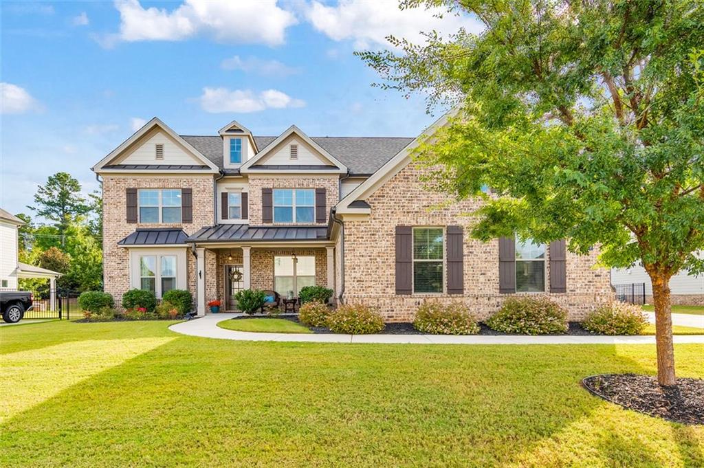 This timeless beauty is ready for you to move right in! Welcome to this stunning 5 bed / 4.5 home built in 2019 that blends modern comfort with elegant design. From the moment you step inside, the open floor plan creates a bright and inviting atmosphere, perfectly suited for both everyday living and entertaining. The gourmet kitchen is a chef’s dream, complete with double ovens, a gas cooktop, vent hood, granite countertops, stainless steel appliances, and white soft-close cabinetry that offers both style and functionality. A breakfast bar and eat-in dining space overlook the two-story great room, where a floor-to-ceiling stone fireplace and a wall of windows flood the home with natural light. The main level also features a formal dining room ideal for hosting dinner parties, a private office with French doors for working from home, and a guest suite with a full ensuite bath. A powder room adds convenience for guests, while detailed trim and thoughtful finishes elevate the character throughout. Hardwood floors extend across the main living areas. Upstairs, the primary suite serves as a true retreat with tray ceilings and a spa-like bath that includes a double vanity, soaking tub, a separate glass-enclosed shower, and an oversized walk-in closet. Secondary bedrooms include a Jack & Jill bath shared between two rooms and an additional bedroom with its own ensuite bath. The laundry room is also conveniently located on the upper level. All bathrooms feature granite countertops and timeless tile finishes. Step outside to the covered patio, the perfect outdoor oasis for relaxing or watching sunsets with family and friends. The three-car garage provides ample parking and storage. This home is nestled in a beautiful neighborhood that offers a scenic lake with a path, providing a peaceful backdrop for evening strolls. Located within award-winning school districts, this home combines luxury living, modern convenience, and an unbeatable setting. Don’t miss the opportunity to make this exceptional property your own.