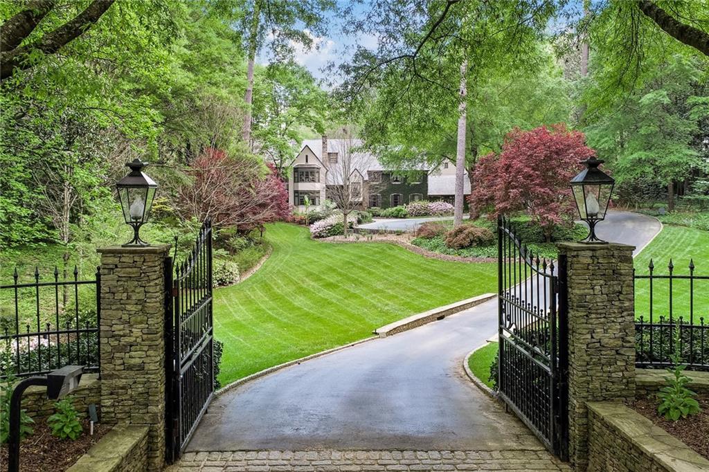 Exquisite property on a most desirable stretch of Tuxedo Road. This breathtaking estate on approximately 4 acres includes expansive landscaping, two small ponds, a spring, and a beautiful bubbling brook in the back of the property. A secret garden in the heart of Buckhead! Generous room sizes and interior highlights include a sunroom with a fireplace overlooking formal courtyard, dining room overlooking the back gardens, and a solarium along the back of the home. 9 ft ceilings on main, and 9 ft ceilings in the upstairs master that includes a sitting room and fireplace. Hardwood floors on main and throughout the upstairs. Three upstairs bedrooms with doors leading to a beautiful large slate balcony overlooking the gardens and ponds. Spacious outdoor sunroom with vaulted ceiling and beams perfect for outdoor living and entertainment. Finished third floor bonus room can be rec room, office, or exercise room. 5 car garage, private carriage house, generator, and more! See the video link!