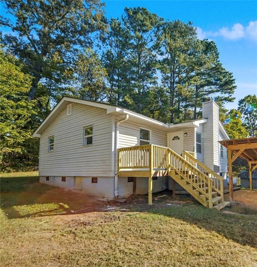 Charming renovated cottage nestled on a private acre in Woodstock. Ideally located off Bascomb Carmel Road, this home offers the perfect balance of convenience and seclusion—close to shopping, dining, and major routes, yet surrounded by peaceful country charm. Completely move-in ready, the home has been thoughtfully updated throughout. The kitchen features new upgraded cabinetry with pull-out drawers, beautiful butcher block countertops, and a classic subway tile backsplash. Additional updates include new LVP flooring and carpet, fresh interior paint, updated lighting and wiring, and a renovated bathroom. A new stackable washer/dryer and two new window AC/heat units add comfort and functionality. Exterior highlights include low-maintenance vinyl siding, a durable metal roof, a spacious front porch, and a large covered parking area. Two outbuildings provide ample storage, with plenty of space remaining for parking work vehicles, boats, or trailers. A wonderful opportunity to own a fully updated home on a large private lot—just minutes from all the amenities and attractions Woodstock has to offer.