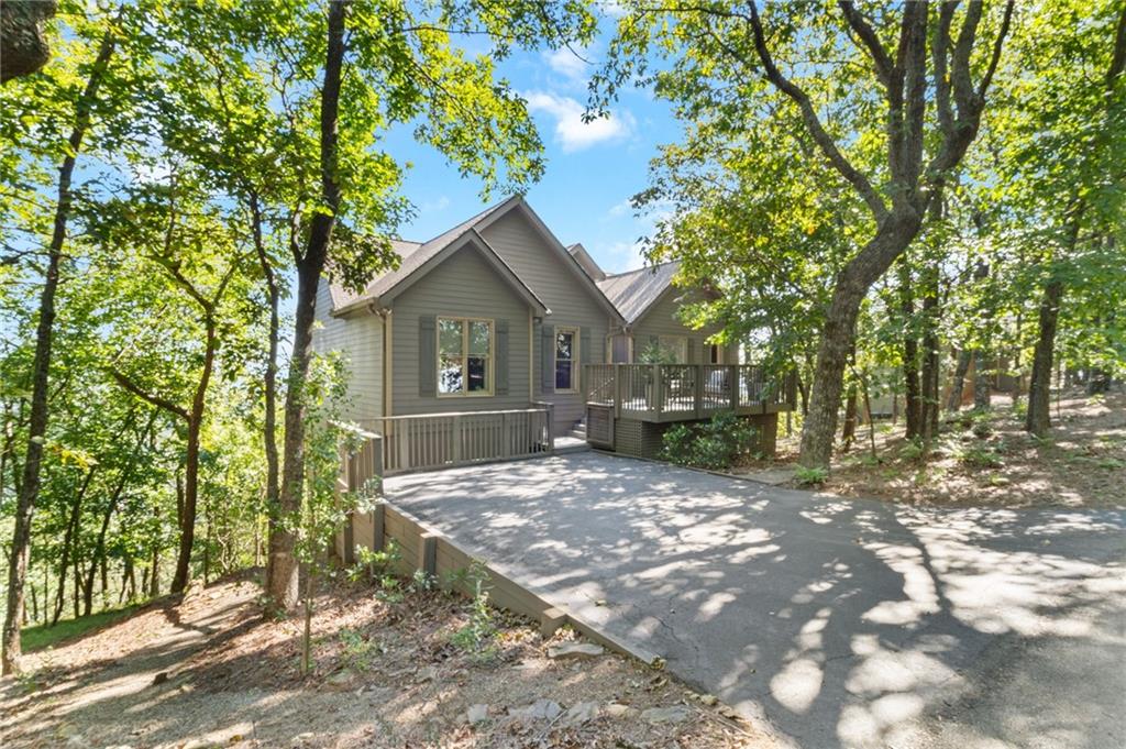 This beautifully appointed and updated 5 B/R - 3 Full Bath design home enjoys an open floorplan with long range unobstructed panoramic mountain views from every vantage point that are absolutely breathtaking. The interior mountain views are quite dramatic, and many proclaim them to be the best in all of Big Canoe. Large Master B/R Suite features a newly built walk-in shower and an enormous window that extends floor to ceiling, plus two additional spacious guest bedrooms and a 2nd full bath plus a small study/office, all located on the main level. Highly sought after wide plank hardwood flooring, cathedral ceiling with large picture windows and a stacked stone fireplace in the great room. The Kitchen has quartz countertops, large breakfast bar, wood cabinets, stainless steel appliances and pantry plus private dining room with panoramic views. Large family room with 2 more bedrooms and 1 full bath located on the terrace, plus an expansive laundry room and utility room for storage. Large outdoor dining area with cathedral ceiling, expansive open deck and level driveway on the main level. The asphalt shingle roof was replaced in 2024, the main level Hvac unit was replaced in 2025, and the terrace level unit was replaced in 2017. Ridgeview Drive is conveniently situated between the Big Canoe Clubhouse and Wolfscratch Village where the amenities are located, and for good measure is just 5 few minutes from the Main Gate for quick and easy access in and out of Big Canoe. A very special find, and won't be disappointed!