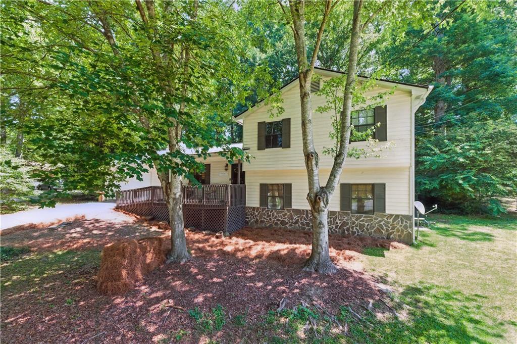 WOW! Tastefully renovated home in an amazing location! This beautiful home has been meticulously renovated over the years for the most discerning buyer. Walk past the two car garage with built in storage, notice the one-year old roof, up the wheelchair ramp and open the front door to a beautiful open concept foyer. Notice the hardwood floors, and extended views through the entire first floor. The open concept first floor also features a bright eat in kitchen with granite countertops, and is open to the sunny dining area and great room. Walk upstairs to a lovely guest bedroom, and guest bathroom that's newly renovated. Once you pass these, you'll enter the amazing primary suite- equipped with a built in sitting room, a newly-renovated bathroom, and it's own deck overlooking the serene fenced in backyard. Everything you would want in a primary suite is in this room! Back down the stairs, you'll find a laundry room, a bedroom with a convenient half bathroom, and two unfinished storage areas. With a private exterior door, this bedroom is perfect for an in-law, young-adult, or multi-generational living! Outside the dining area on the main level, you'll find a second deck that features a storage shed and accents the serene backyard. This home is within a few minutes of shopping, dining, and top-rated schools. Be at the Mall of Georgia within 10 minutes! Run, don't walk, to see this showpiece today!