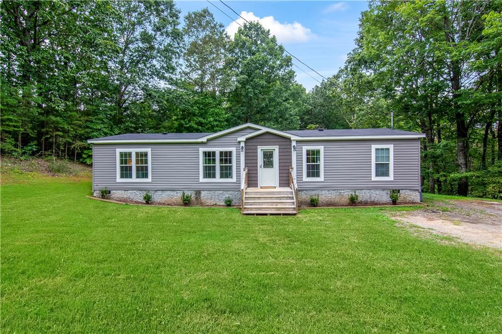 Experience refined country living in this impeccably maintained, permanent foundation, 3-bedroom, 2-bath, sole-owner residence in the heart of Ellijay, GA—offering no HOA, no restrictions, and the perfect blend of privacy and convenience. Just 8 minutes from Walmart and moments from Clear Creek Middle School, this home is tucked away on all paved roads with excellent cell service.
Inside, discover numerous upgrades throughout, including underlighting in the master bathroom, elegant LVP floors, and premium finishes. The light-filled living room features a sleek electric fireplace, flowing seamlessly into a chef’s kitchen with an expansive island, rich wood cabinetry, a huge walk-in pantry, abundant storage, and 2023 stainless steel appliances. The private owner’s suite is a true retreat with an oversized bedroom, a huge walk-in master closet, and a spa-like bath boasting a soaking tub, double vanities with custom wood-accent mirrors, and a stunning tile-surround shower. Two additional bedrooms, a stylish guest bath, and a well-appointed laundry room with outdoor access complete the interior.
Recent updates include a 2023 AC unit, hot water heater, and shingle roof, providing peace of mind and making financing easy thanks to the permanent foundation.
Outside, enjoy a huge, flat, fully usable backyard beautifully enhanced with planted Green Giant trees for added privacy, along with two outbuildings—a 10 x 14 and a 10 x 20 storage shed—offering endless potential for outdoor living. This is more than a home; it’s a serene retreat just minutes from town.
