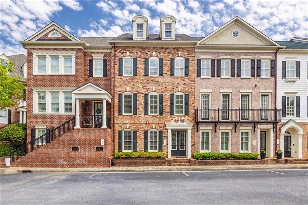 ELEVATOR service to all 4 floors! This beautiful townhome has been freshly painted throughout the entire home, with hardwood floors on the 1st & 2nd levels, and newer carpet, located in the well-established sought-after One Ivy Walk, one of Smyrna/Vining's most popular gated John Weiland communities. From the moment you walk into this unit, you will love the entry foyer's high ceiling and beautiful double doors. On the 1st floor, you will find a full bedroom with French doors that can also be used as an additional living space or office with a full bathroom. The main level of this home offers an open floor plan, perfect for entertaining! The kitchen, with an oversized island, plenty of cabinet space, stainless steel appliances, and granite countertops, opens to one of the many sitting areas/ family spaces. The dining room is perfectly positioned between the kitchen and another large living space with a gas fireplace. On the third floor, you will find the oversized primary suite offering an additional space perfect for a reading nook, plus two walk-in custom closets. You are sure to enjoy relaxing in the whirlpool tub! There are double vanities and an oversized double frameless glass shower. On the same floor, you will find a guest suite with a private bathroom offering a tub/shower combo. There is a conveniently located laundry room with a sink and cabinets. On the 4th floor there is yet another oversized guest suite with a living space plus another full bath with tub/shower combo. Do not miss all the storage the 4th-floor offers. If shopping is your thing, there are numerous shops as well as a spa & nail salon just before the entry gates of One Ivy Walk. It is only a short walk to The West Village for more restaurants and shopping and less than a 5 min drive to Vinings Jubilee or The Battery-Trusit Park. Easy access to I-285 & I-75, only 15 minutes to Buckhead, Midtown, or D'town, and 20 min to ATL airport. The community offers a newly renovated gym and a beautiful clubhouse overlooking one of the best community pools in Smyrna. If you have a dog, there is a dog park too! Do not miss out on this stunning unit and a rare opportunity to live in the prestige One Ivy Walk. Make your appointment today.