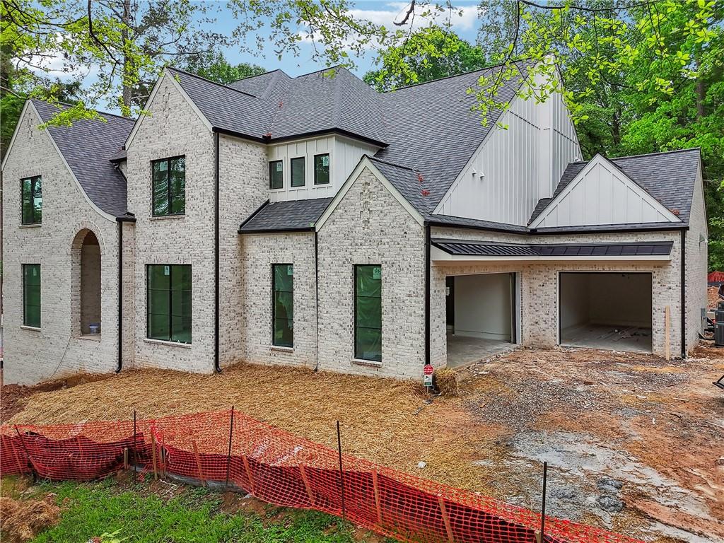 Alluring clean-line transitional design meets exceptional craftsmanship in this all-brick new construction located on over an acre in the quiet, highly desirable Kingston neighborhood. Thoughtfully designed with natural light in mind, this home features expansive 8’ metal-framed windows and doors throughout, creating bright, airy living spaces with seamless indoor-outdoor flow. An arched front entrance leads into a two-story foyer flanked by a formal dining room and a fully equipped butler’s pantry with wet bar, ice maker, and beverage cooler. The heart of the home is the dramatic two-story vaulted great room with a floor-to-ceiling stone fireplace and 10’ sliding glass doors. The chef's kitchen with custom beaded inset cabinetry pairs with a large waterfall island, dual dishwashers, 48” slide-in range, 48" sub zero fridge, hidden walk-in pantry, and a scullery featuring a second refrigerator, sink, and dishwasher for effortless entertaining. The breakfast room offers picture-frame views and opens to a vaulted, auto-screened lanai with skylights, built-in grill, and fireside dining area—overlooking a private backyard oasis with heated saltwater pool, spa, tanning ledge, and a dedicated pool bath. The main level includes a private office with pool views, mudroom with built-in lockers, powder room, and one of two primary suites. The main-level primary features its own fireplace, spa bath with soaking tub, large Kohler-equipped shower, dual custom wood vanities, and a walk-in closet with stackable washer/dryer hookups. Upstairs, the second primary suite offers a spa-style bathroom with dual vanities, soaking tub, large walk-in shower, and generous closet. Three additional ensuite bedrooms include walk-in closets, designer tile, and Kohler fixtures. The finished terrace level is ideal for entertaining with a full wet bar, recreation room, media/gym space, half bath, and a full ensuite bedroom. This home is loaded with upgrades and will be completed by June. Centrally located with convenient access to Chastain Park, Brookhaven, and top public and private schools, this one-of-a-kind home offers luxury, privacy, and sophistication in one of Atlanta’s most coveted communities.