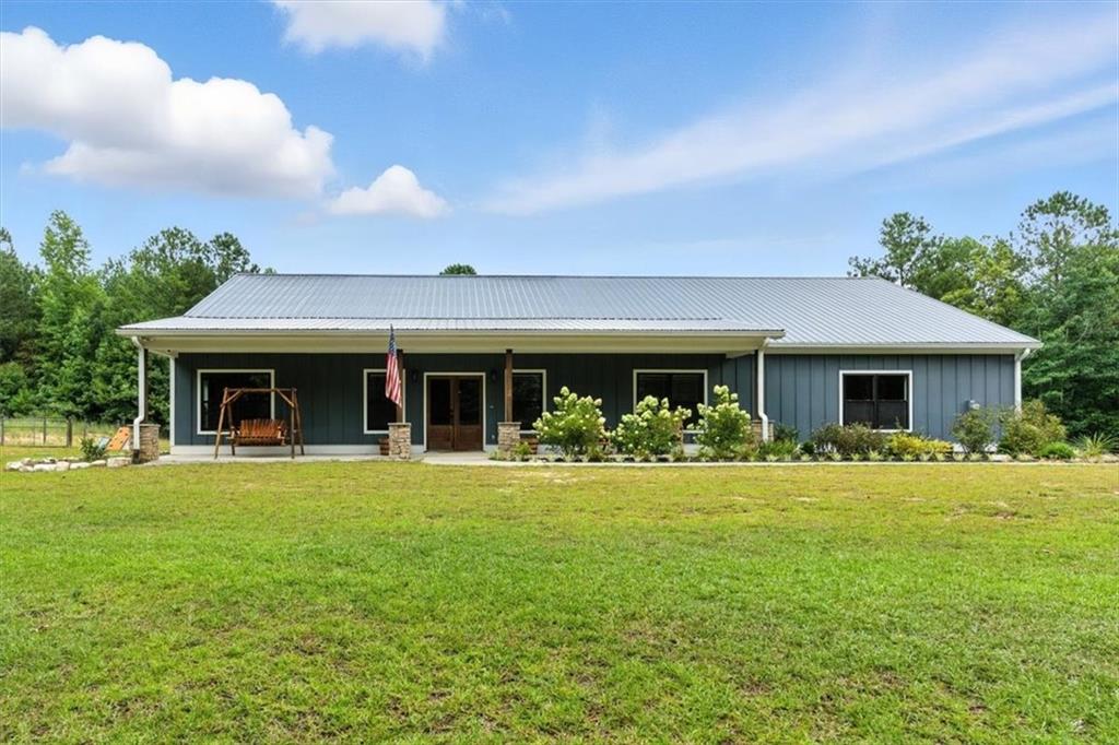 Welcome to 1235 Williams Rd—a true hidden gem in North Paulding offering peaceful seclusion, modern conveniences, and endless possibilities on 10.5 private acres with a gated entrance, dedicated RV parking space with an electrical hookup, making packing, unloading, or accommodating out-of-town guests easy and convenient. Outdoor lovers will appreciate private access to Pumpkinvine Creek, perfect for fishing or playing in the water right on your own land. Built in 2020, this stepless ranch home features 3 bedrooms, 2 full bathrooms, and a large flex room with a wet bar perfect for a home office, game room, or oversized dining space. The bright, open-concept layout centers around a stunning kitchen with a huge island, granite countertops, stainless steel appliances, and a stacked stone fireplace. Enjoy the practicality of a large laundry room with its own sink, perfect for pre-soaking or quick clean-ups. The primary suite offers plenty of room for large furniture and includes a luxurious en suite bathroom with an oversized tile shower, dual-sink vanity, and a walk-in closet. Enjoy the efficiency of a tankless water heater and the peace of mind that comes with filtered well water. No need to worry about internet access—fiber and high-speed internet service is already available! Step out to the screened back porch and enjoy views of your fenced backyard with frequent visits from deer, turkey, and other wildlife. The oversized 10’ garage doors provide ample space for trucks, recreational vehicles, or storage. Whether you're looking for complete privacy, building a mini farm, or a property ready for entertaining—this one checks all the boxes.