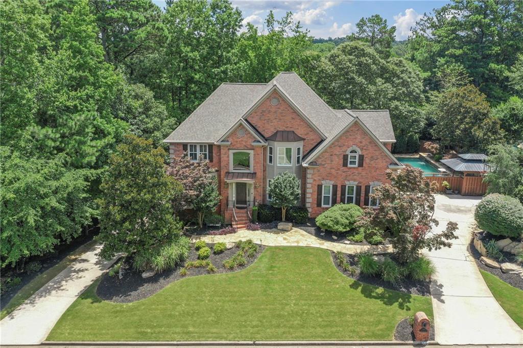 Property appraised for over asking price and beautifully renovated and upgraded throughout, the spacious Six-bedroom, 5.5-bath pool home in desirable Johns Creek. The house is very open and bright, making it an ideal space for entertaining. It features a 2-story family room with built-in cabinets, a fireplace, floor-to-ceiling windows, a formal living room, and a dining room with a butler’s pantry. The gourmet kitchen features stainless steel appliances, including a Viking 5-burner gas stove, double ovens, a Miele dishwasher, and an expansive island that seats 6. The keeping room has a fireplace with an adjoining heated and cooled sunroom. The guest suite on the main level has a full bath. Upstairs, there are four bedrooms and three full bathrooms featuring all-new cabinetry, granite countertops, mirrors, tile, and lighting. The owner’s suite has a new oversized shower, soaker tub, expansive vanity, new cabinetry, new tile flooring, lighting, and mirrors. The finished terrace level features a family room with a pool table, new tile floors, a bedroom, a full bath with new cabinetry, a climate-controlled storage room, an art studio, and a workout room. The home also features a high-end new HVAC and Air Filtration system, a central dehumidifier system, new ducts, and a new water heater.
Hardwood floors are installed in all bedrooms, and new carpet is featured in all stairwells. New 40-year roof, 2021. Custom-built garage storage cabinets and cubbies. New plantation shutters throughout. Enjoy outdoor living in the backyard with a meticulously maintained saltwater pool, waterfalls, two spillover spas, a large flagstone patio featuring a fire pit, and a covered outdoor cabana area perfect for grilling. Large landscape rocks with beautiful magnolia trees and knockout rose bushes. The property features two driveways, one on either side of the home, providing ample space to park all your vehicles. The community has active swim and tennis teams, a playground, and a clubhouse. Close to shopping and restaurants, and easy access to GA 400. Top-rated Johns Creek schools!
Property appraised for over asking price!